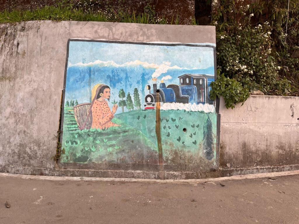 A mural in Darjeeling, a small hill station in India's northeast, depicts tea gardens and a toy train. Some polling stations in this hilly region require poll workers to trek for hours through jungles and ferry polling equipment on mules