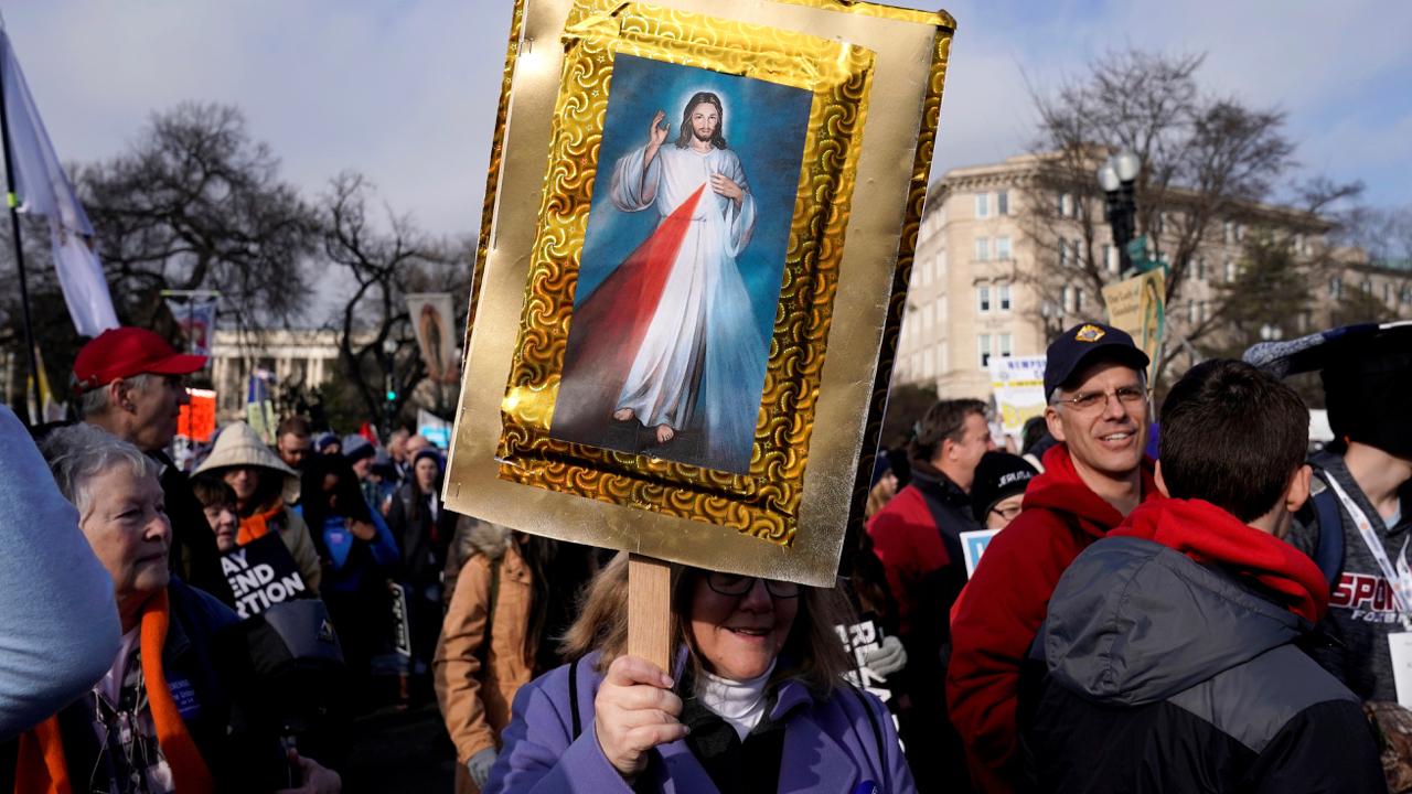 An anti-abortion marcher carries a picture of Jesus Christ during a rally at the Supreme Court during the 46th annual “March for Life” in Washington, D.C. on January 18, 2019.
