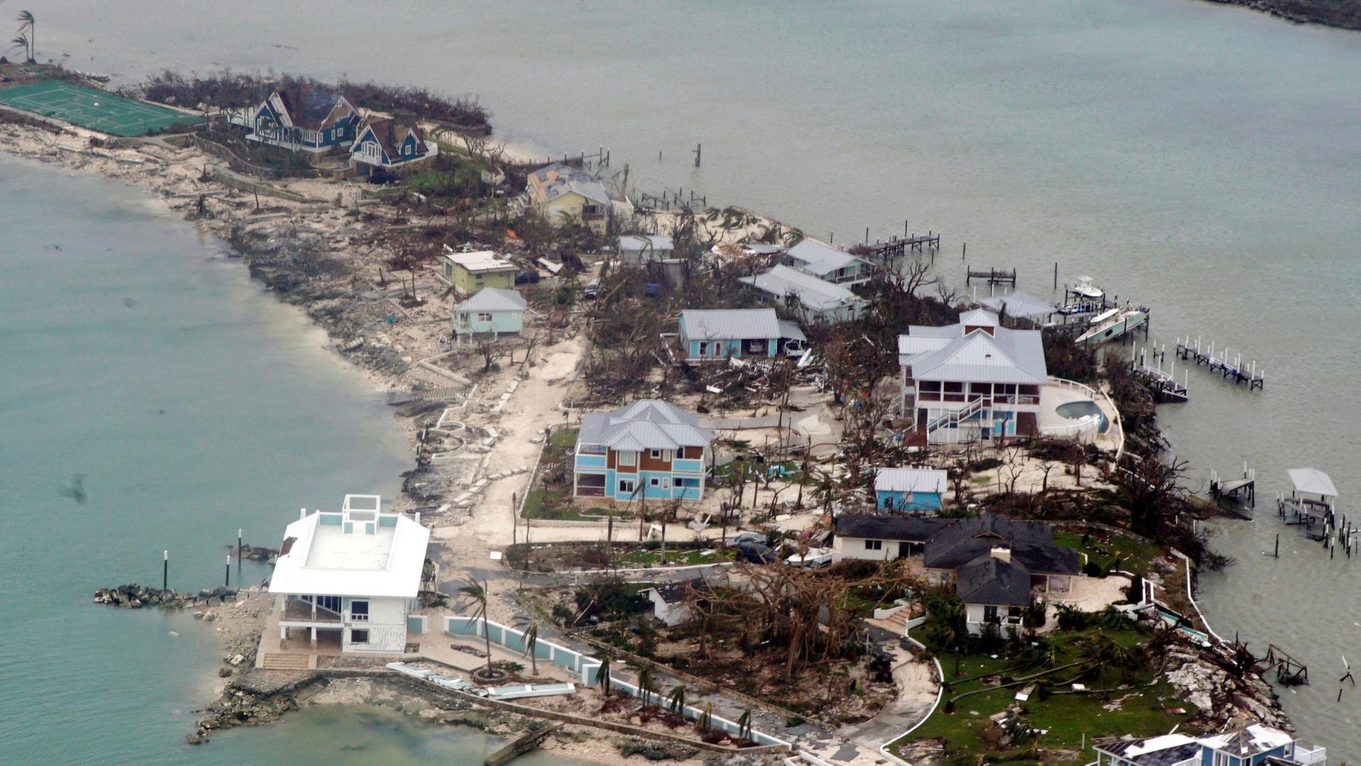 An aerial view of damaged homes, trees and extra debris surrounded by water in the Bahamas.