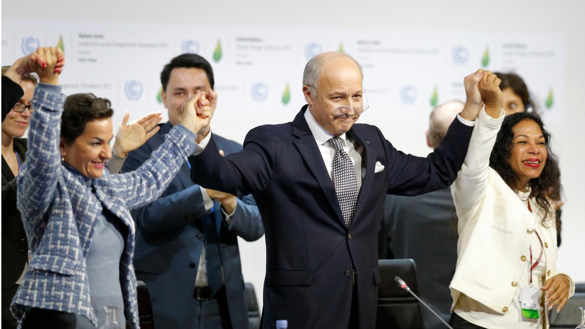 French Foreign Minister Laurent Fabius (C), president-designate of the UN climate summit, and Christiana Figueres (L), executive secretary of the UN Framework Convention on Climate Change, celebrate during the final session of the World Climate Change Con