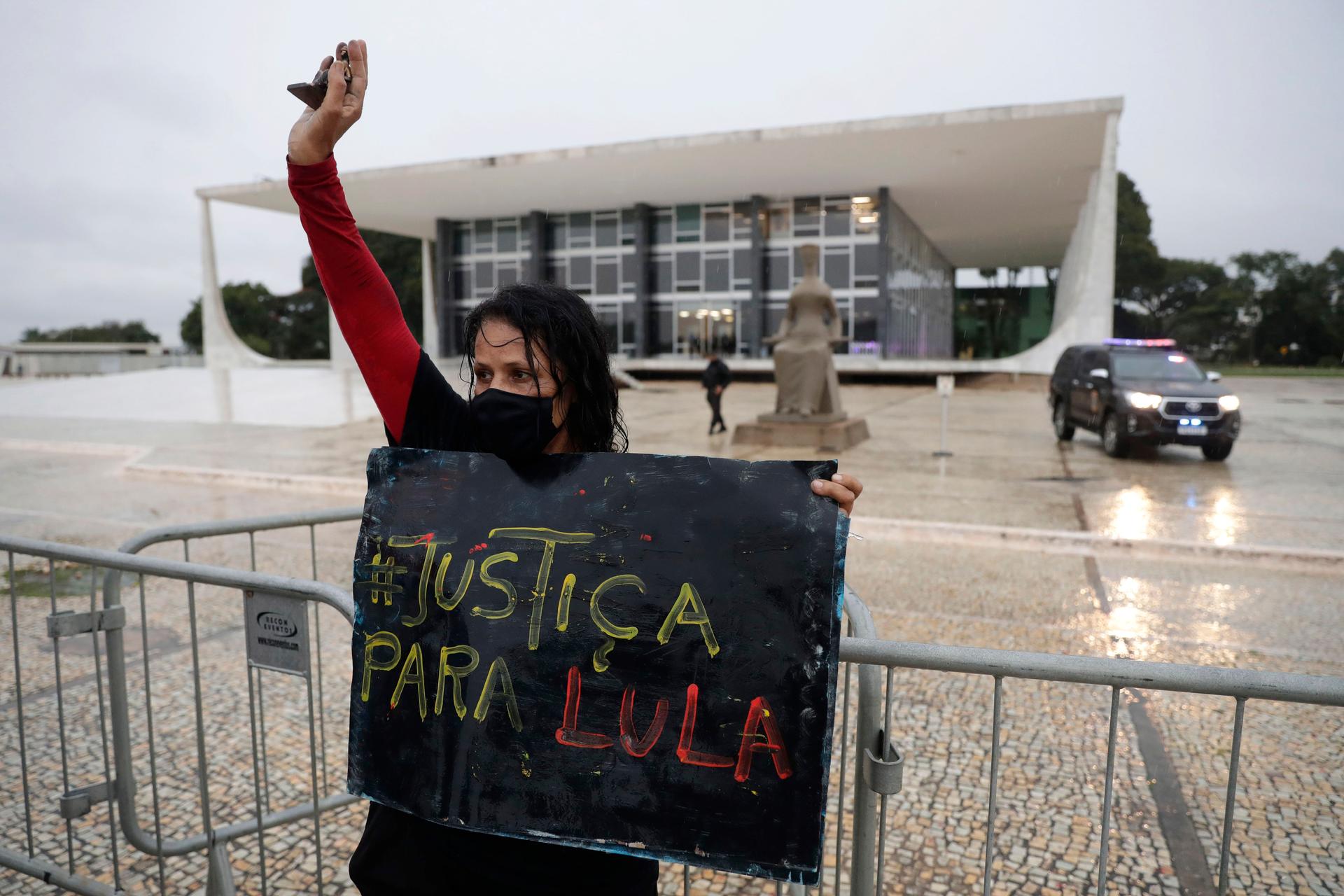 A demonstrator wearing a mask against the spread of the new coronavirus holds a sign that reads in Portuguese "Justice for Lula," in reference to former Brazilian President Luiz Inácio Lula da Silva, during a protest commemorating the Supreme Court's deci