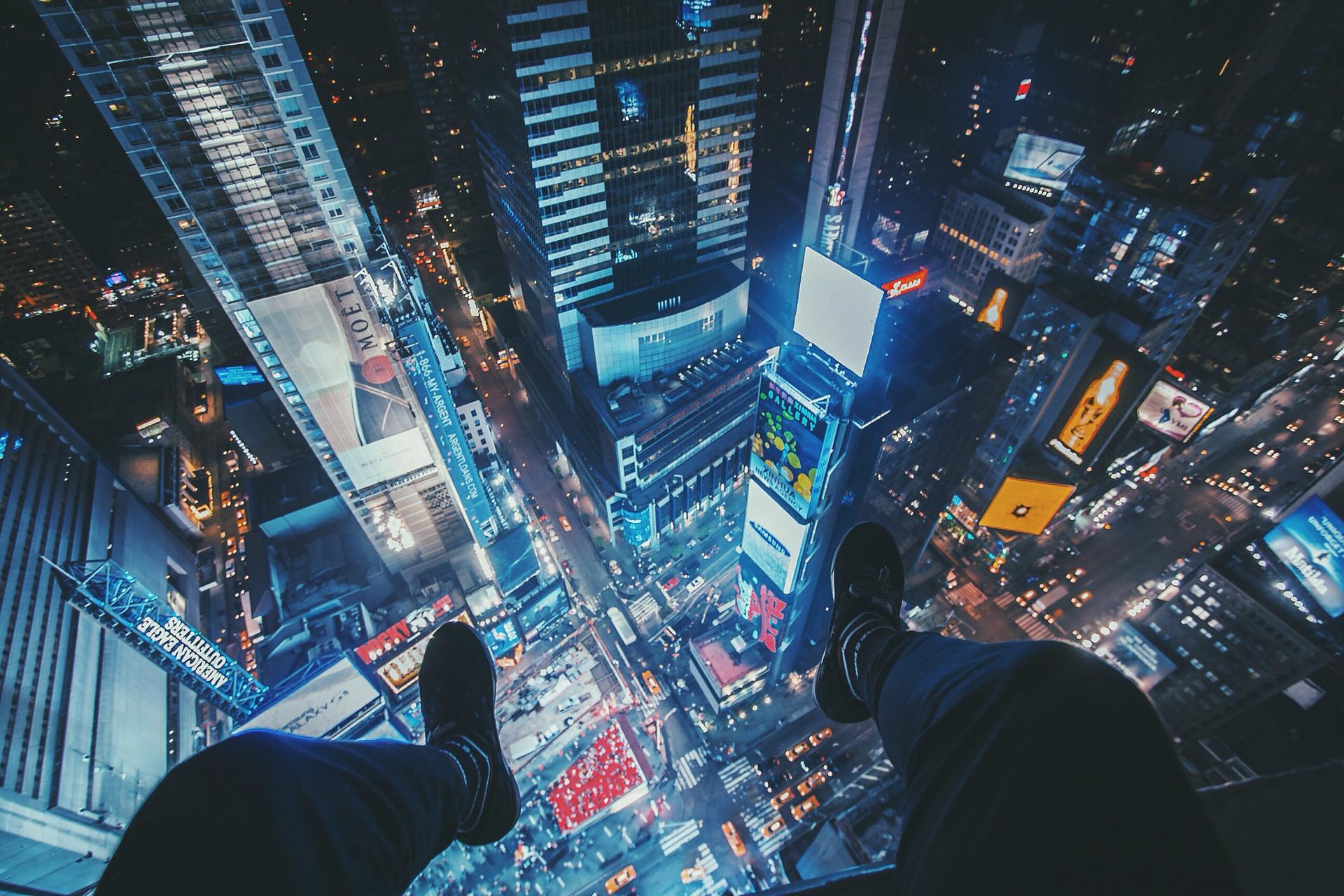 Humza Deas dangles his feet over Times Square.