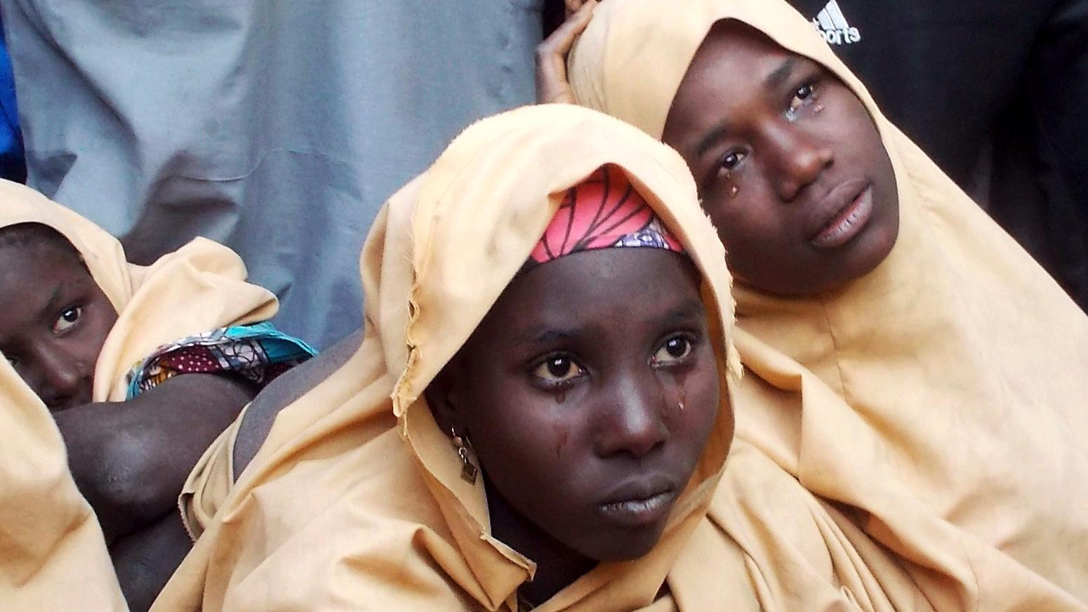 Some of the newly-released Dapchi schoolgirls are pictures in yellow coverings while sitting. Tears are coming from their eyes.