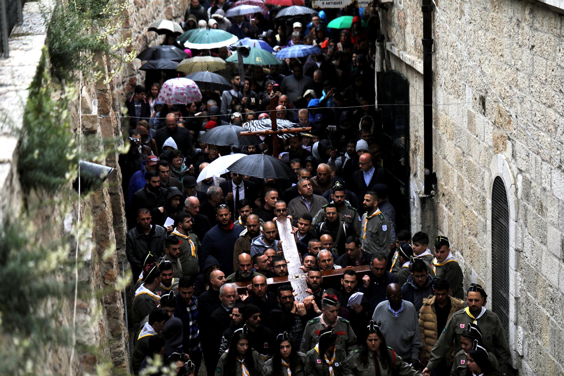 Worshippers carry a large wooden cross during a Good Friday procession along the Via Dolorosa in Jerusalem's Old City, March 30, 2018.