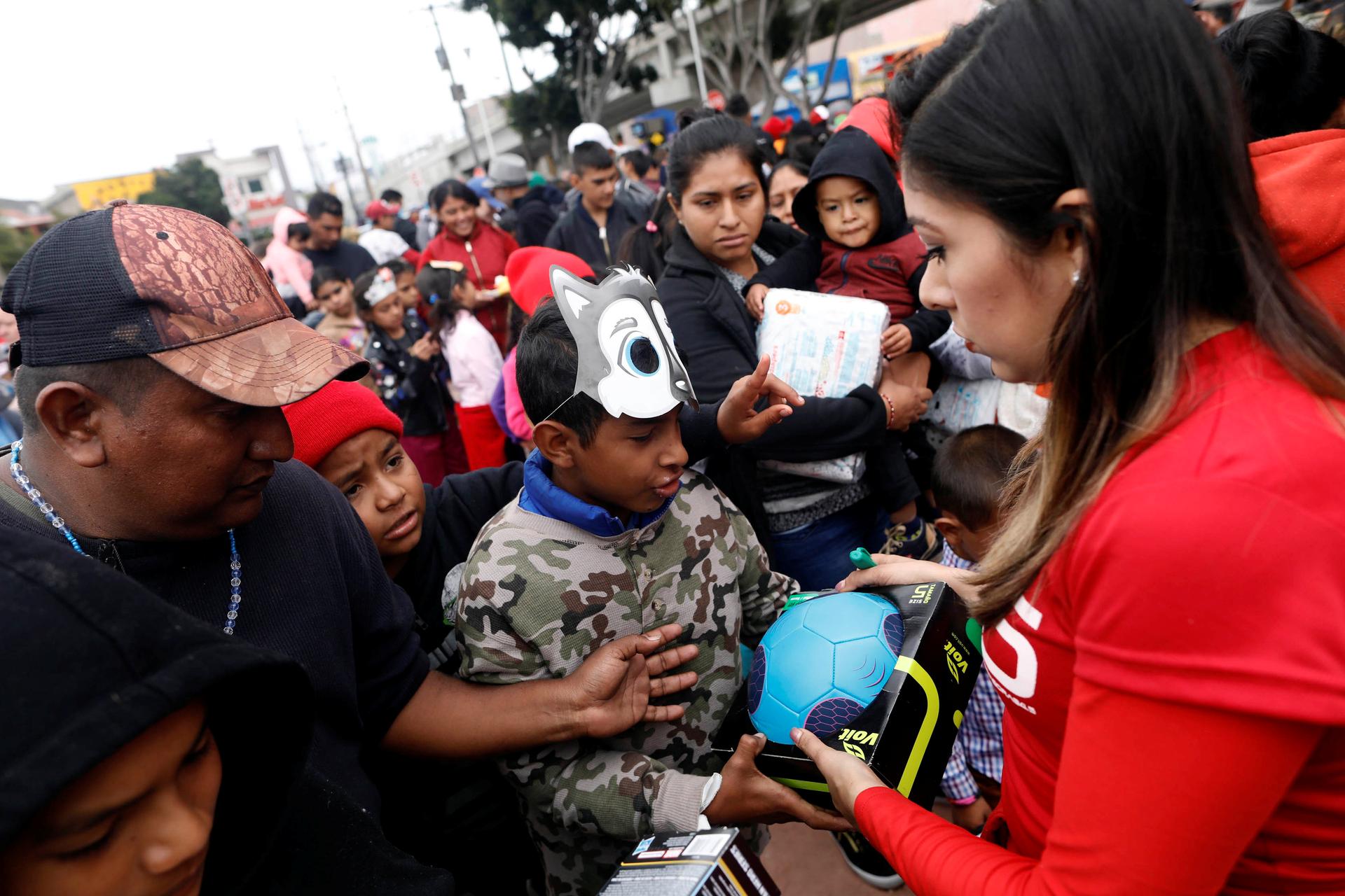 People hand out presents to children traveling with a caravan of migrants from Central America, near the San Ysidro checkpoint in Tijuana, Mexico April 30, 2018.