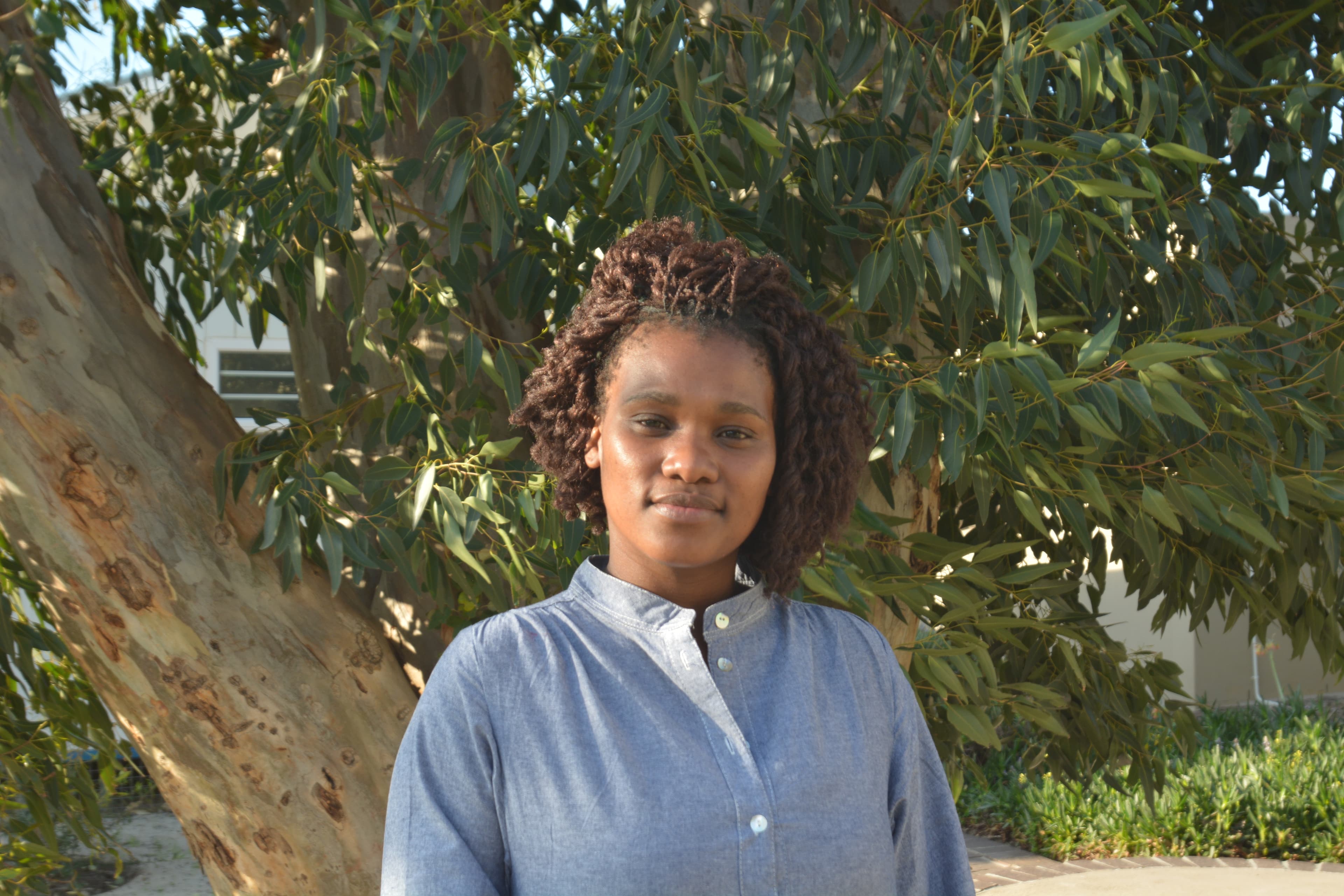 Ziyinda Kamte stands in front of a tree