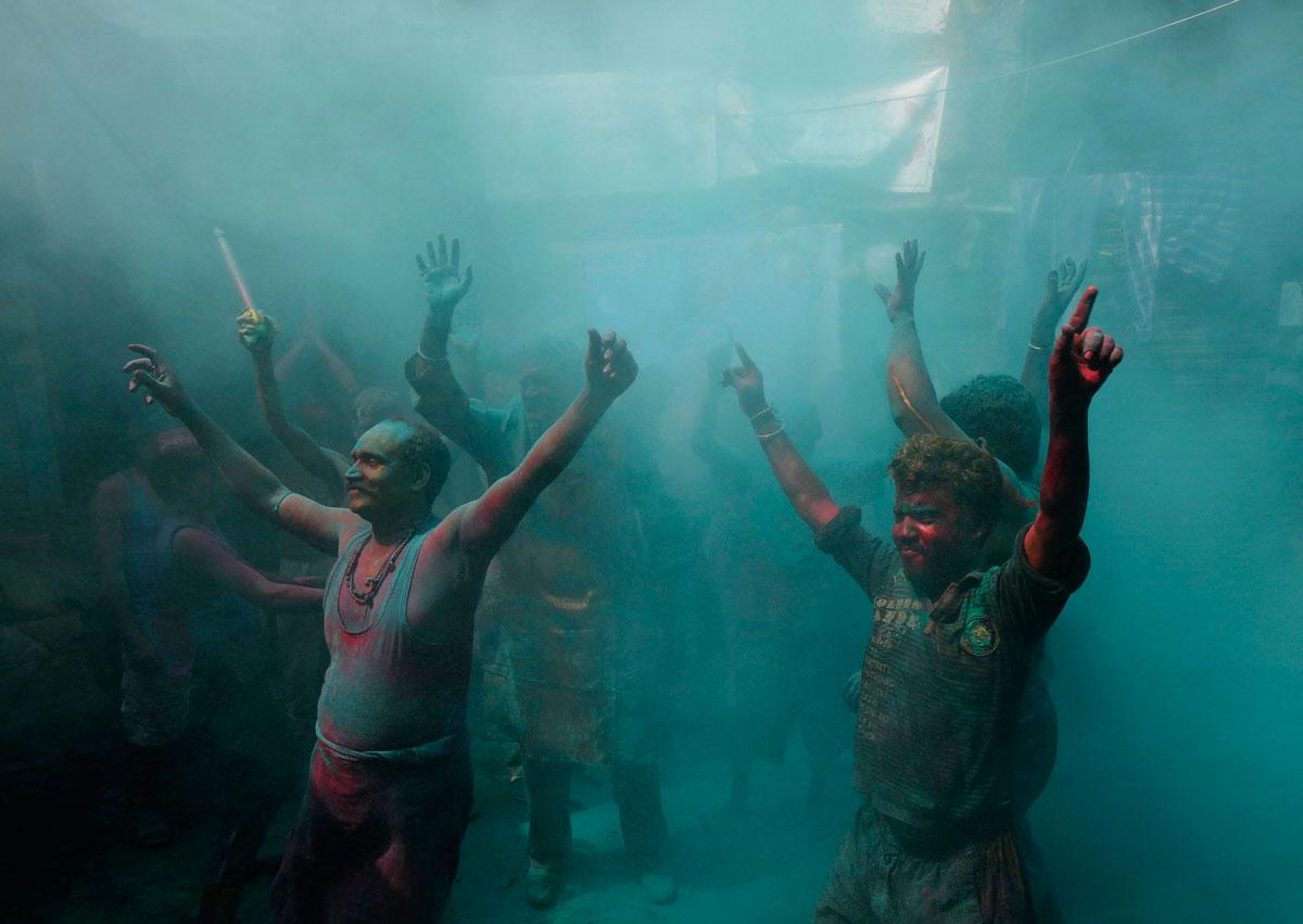 Men dance during Holi celebrations.