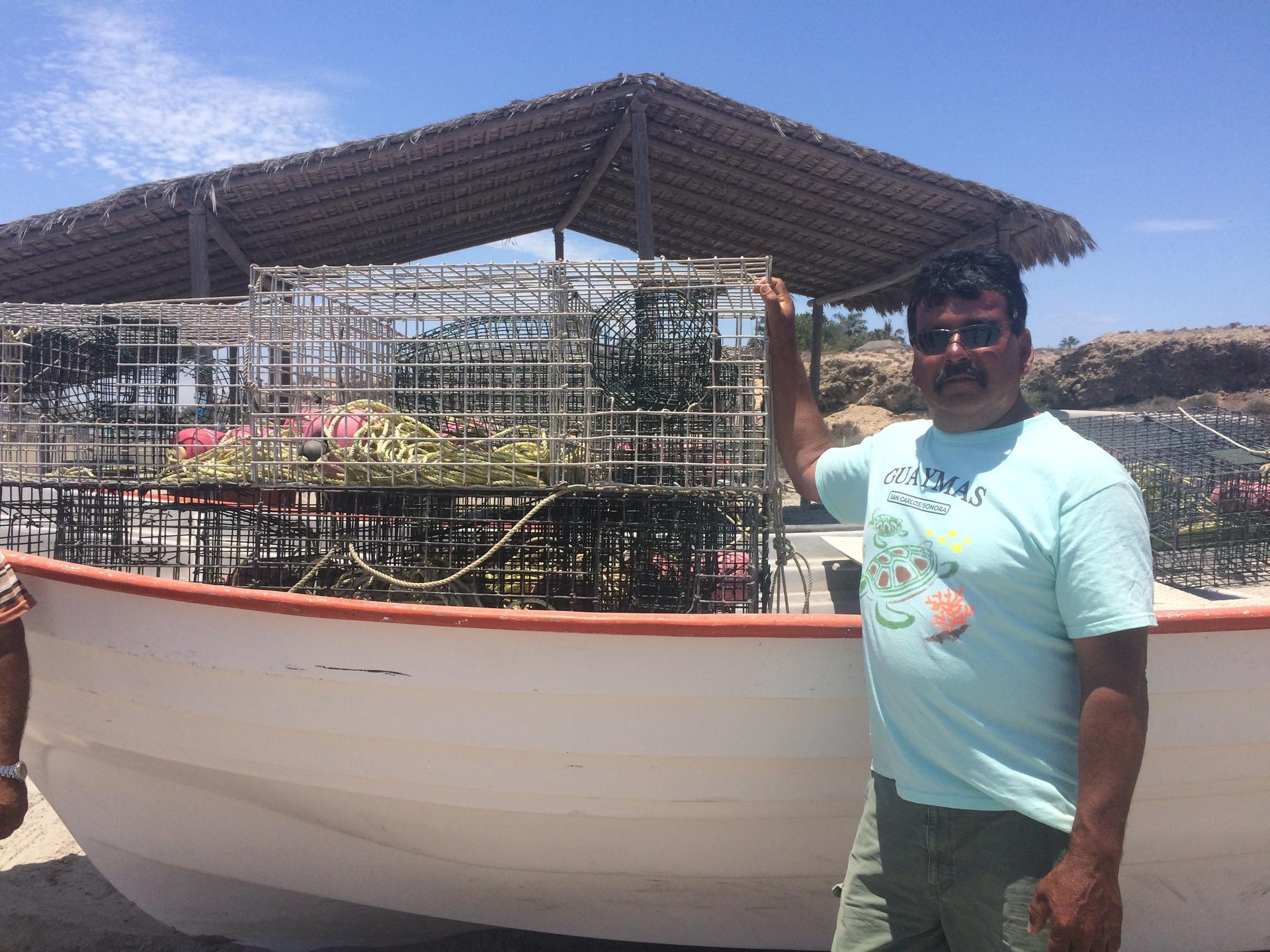 Fisherman Juan Luis Aguilar stands by his boat full of lobster traps and nets on the beach at San Juanico. He and other members of the local fishing cooperative fear the proposed undersea phosphate mine will put them out of business.