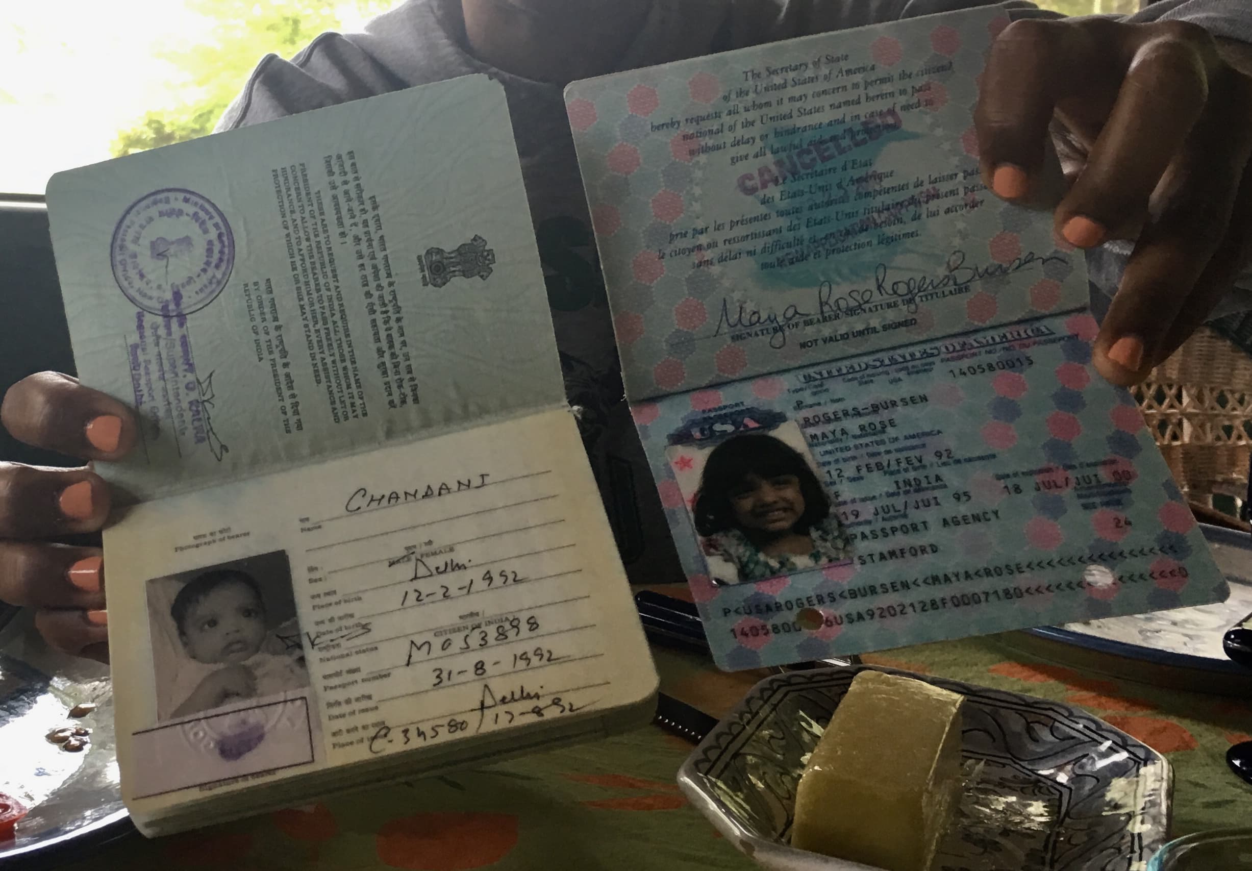 Maya Rogers-Bursen, 26, holds her old Indian passport and a newer American one, each with different names.
