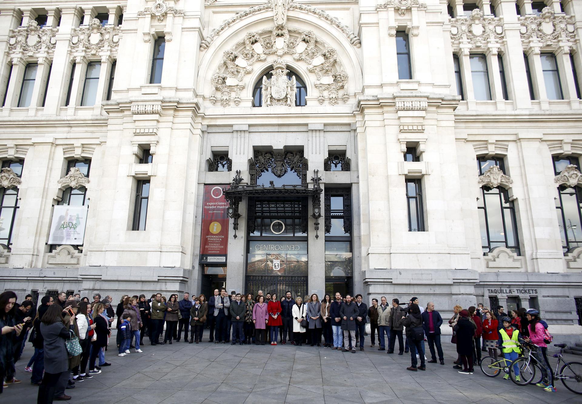 Madrid Mayor Manuela Carmena (C) stands with other politicians including Podemos (We Can) party leader Pablo Iglesias while observing a minute of silence for the victims of the Brussels attacks in front of city hall in Madrid, Spain, March 22, 2016.