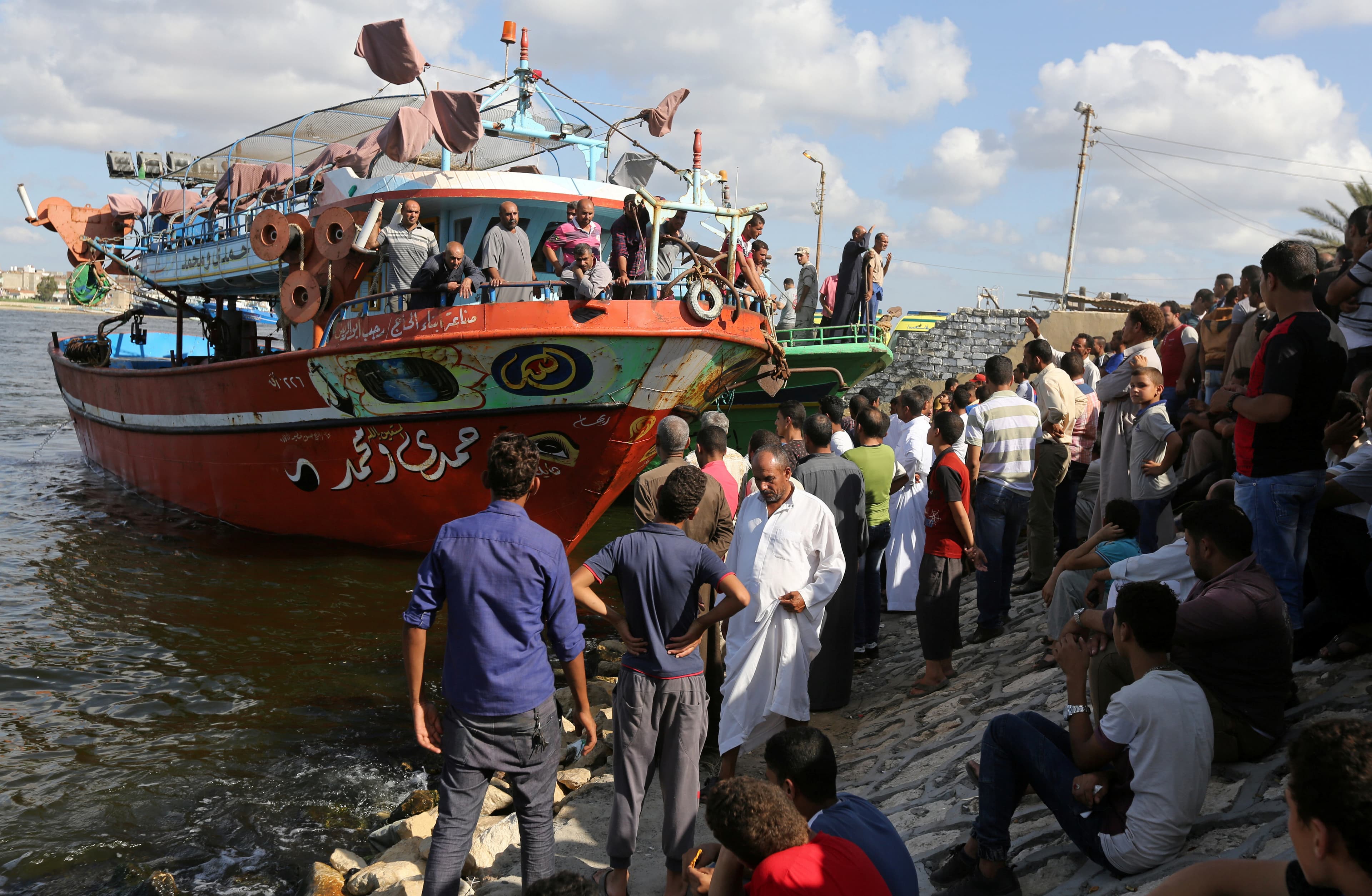 People gather along the shore of the Mediterranean Sea during a search for victims after a migrant boat capsized, in Al-Beheira, Egypt, September 22, 2016.