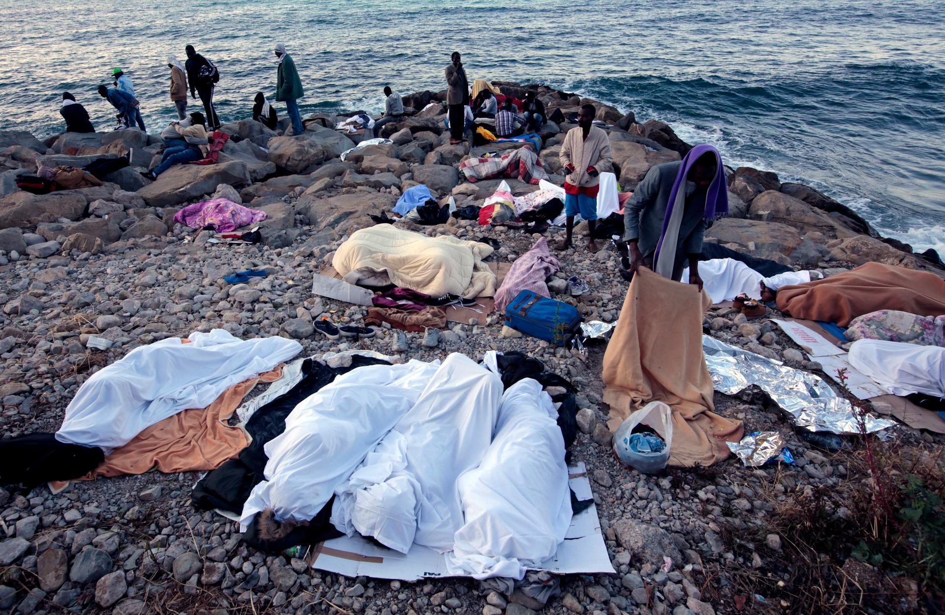 Migrants sleep on the rocks of the seawall at the Saint Ludovic border crossing on the Mediterranean Sea between Vintimille, Italy and Menton, France, June 15, 2015.