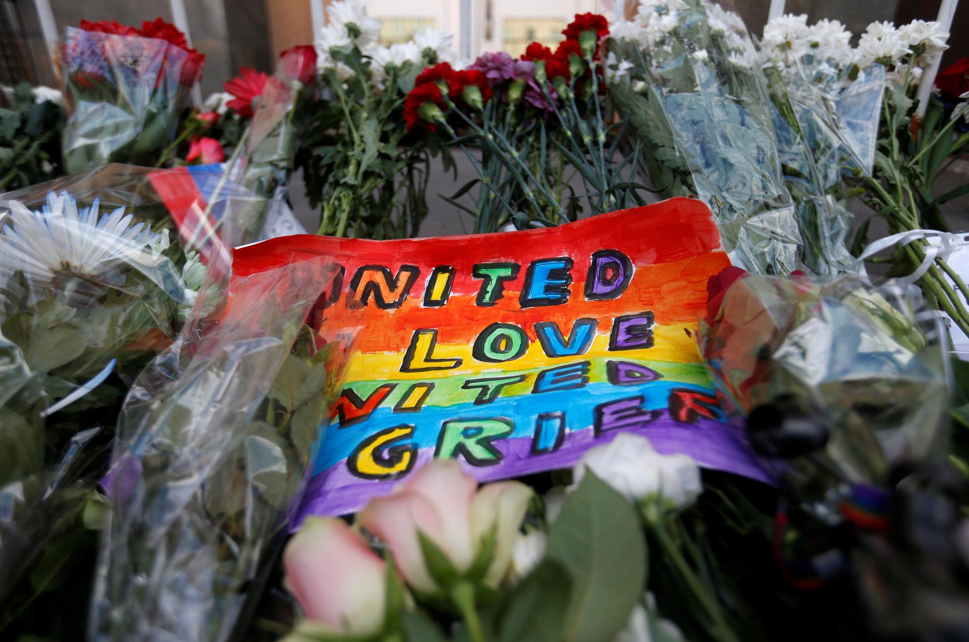 A placard and flowers for the victims of the shooting at a gay nightclub in Orlando are seen in front of the U.S. Embassy in Moscow, Russia, June 13, 2016.