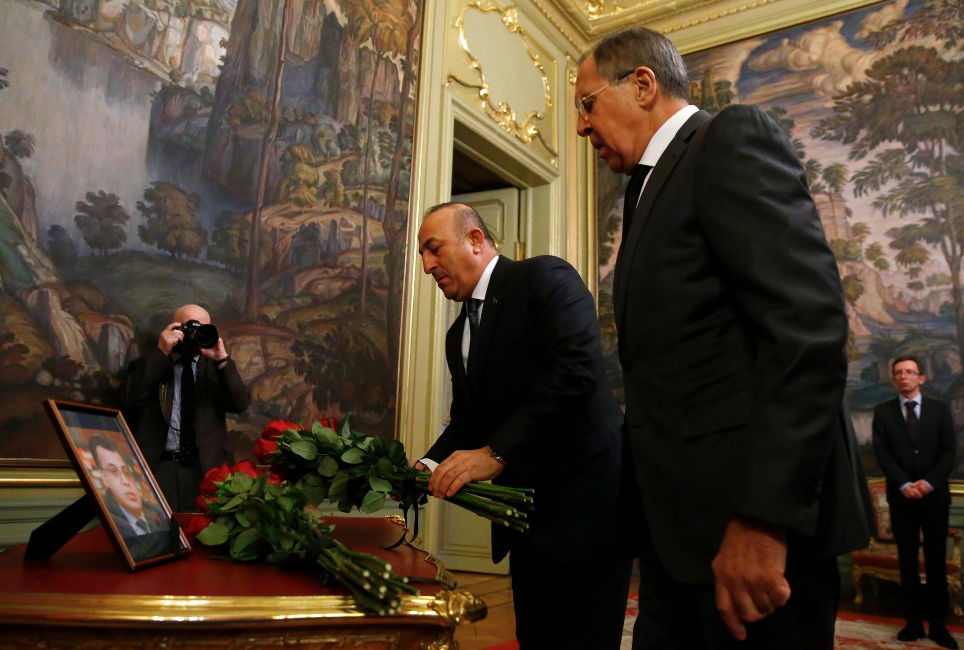 Russian Foreign Minister Sergei Lavrov (R) and his Turkish counterpart Mevlut Cavusoglu lay flowers in memory of murdered Russian ambassador to Turkey Andrei Karlov