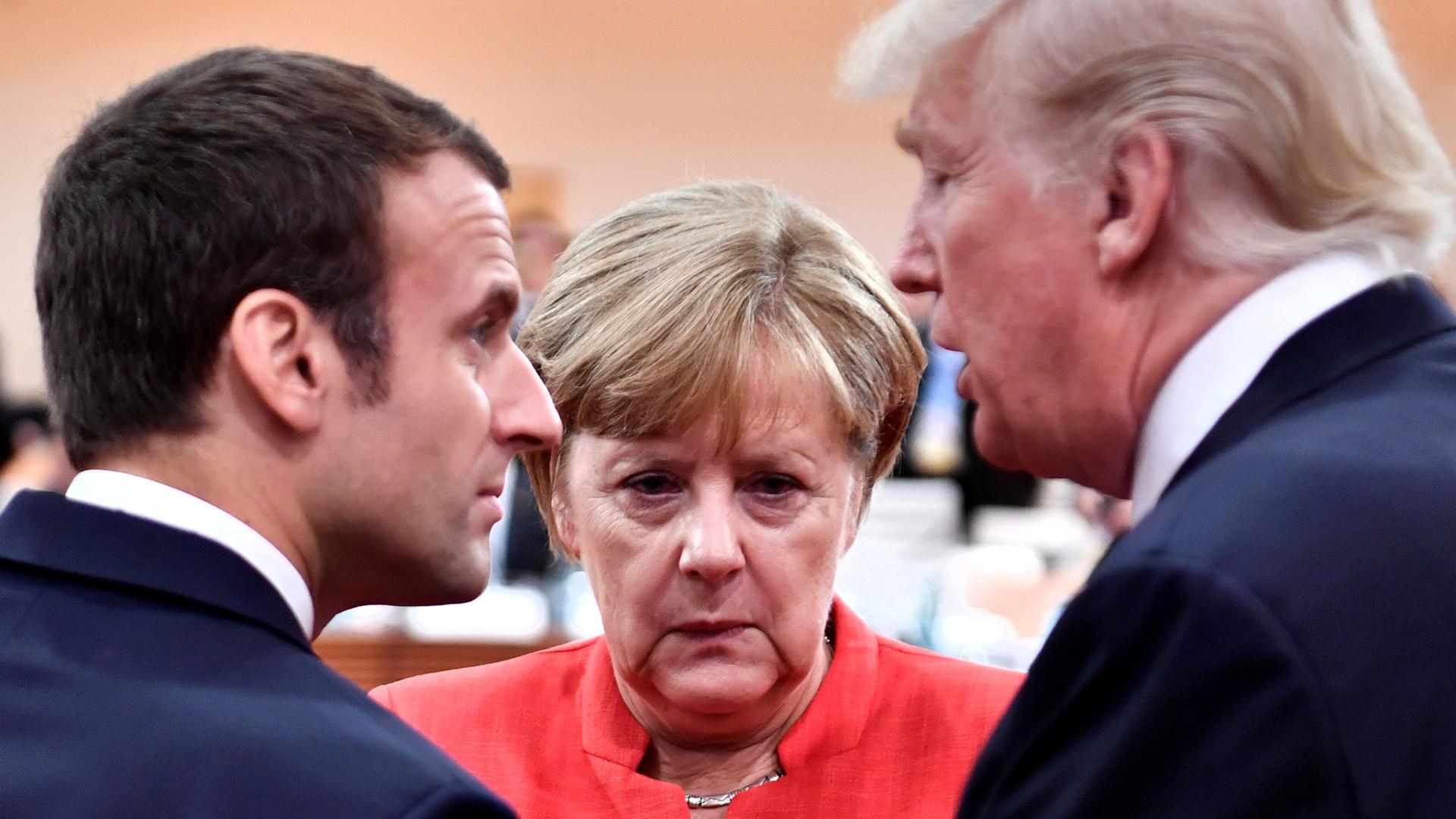 French President Emmanuel Macron (L), German Chancellor Angela Merkel and US President Donald Trump confer at the G20 meeting in Hamburg, Germany, July 7, 2017.