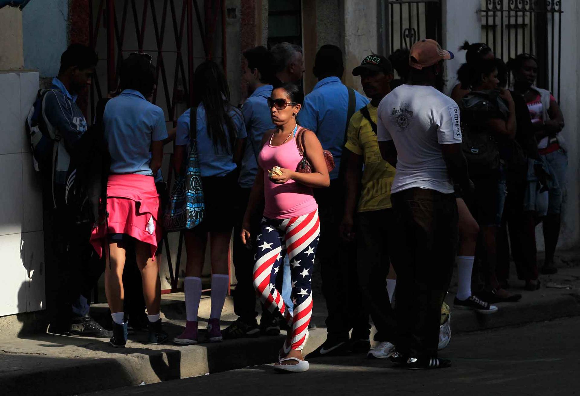 A woman wearing pants with the colors of the US flag walks on a street in Havana, December 2014.