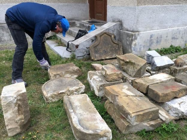 A man restoring headstones.