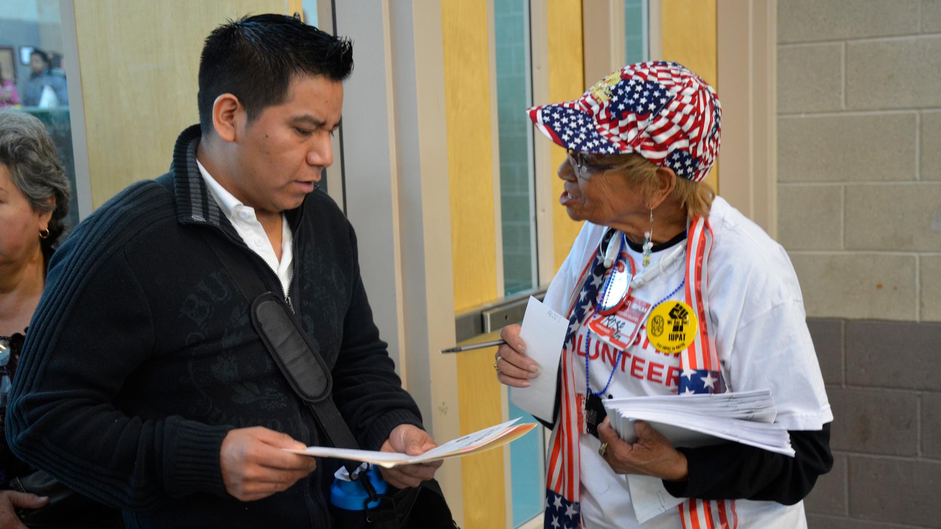 A  volunteer helps a hopeful American citizen navigate the citizenship fair in Las Vegas.