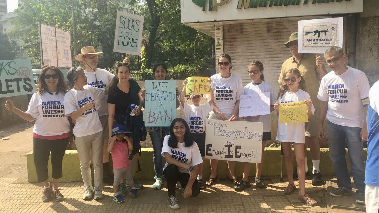 A group of Americans and Indians posing with posters in Mumbai in support of March for Our Lives.