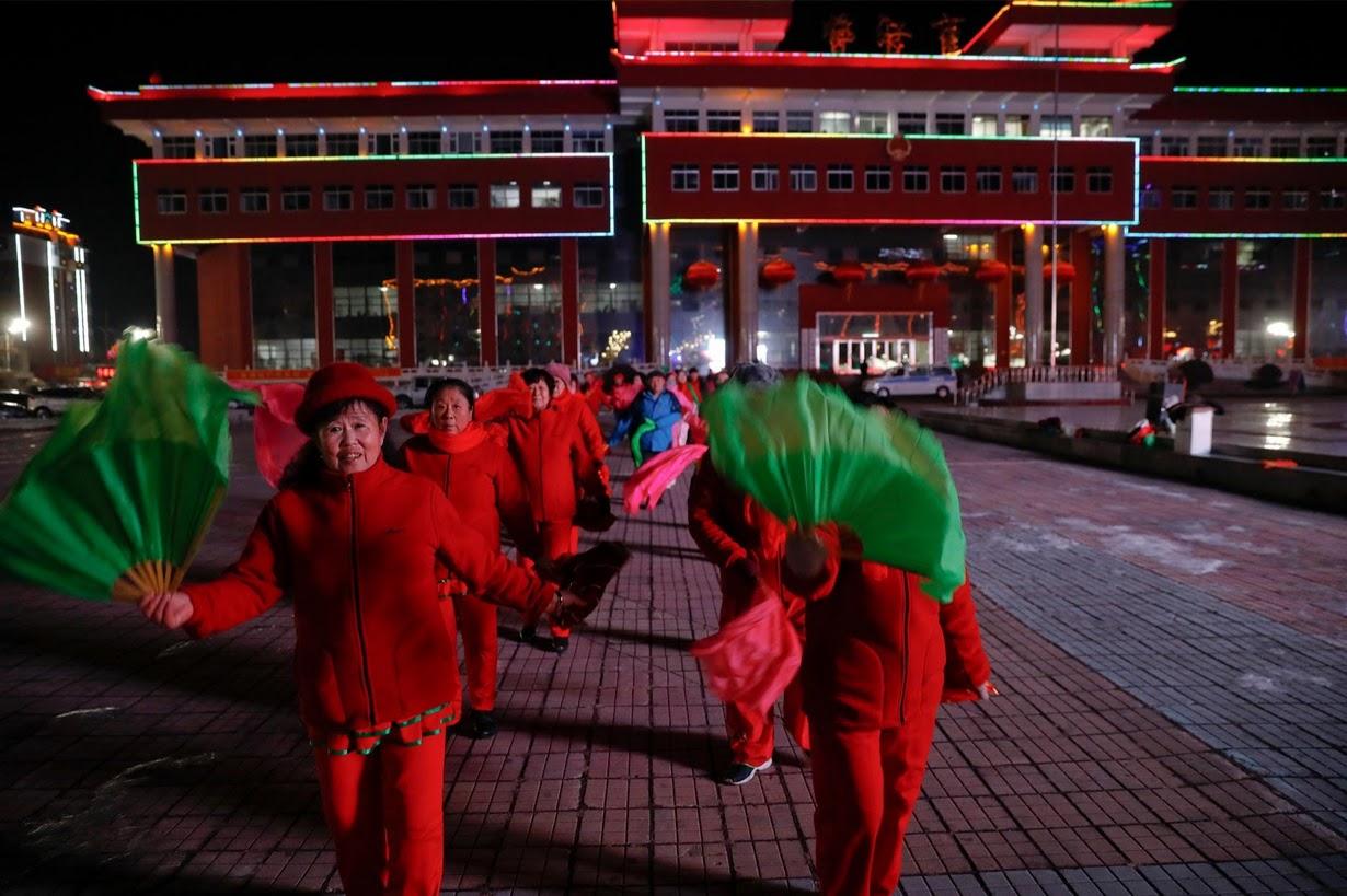Women participate in a group dance exercise close to the Yalu River