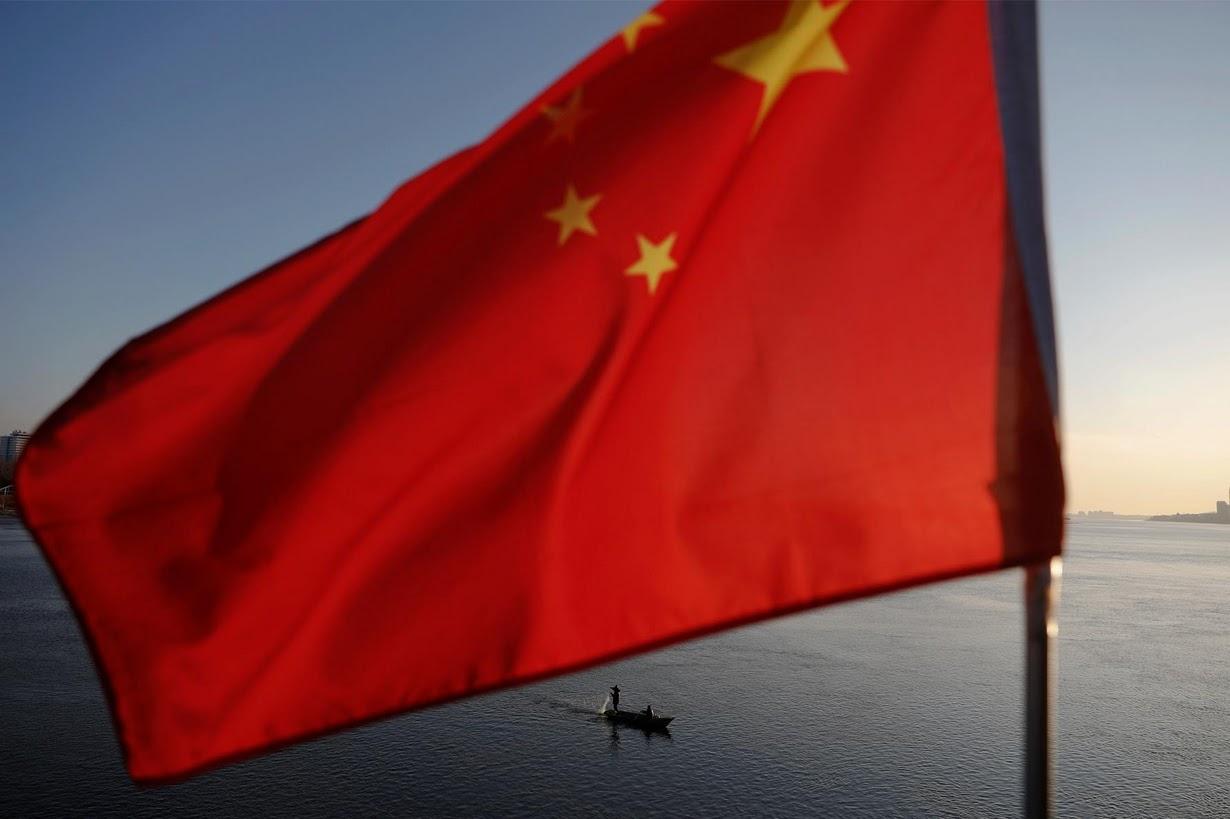 North Korean fishermen are seen as a Chinese flag flutters