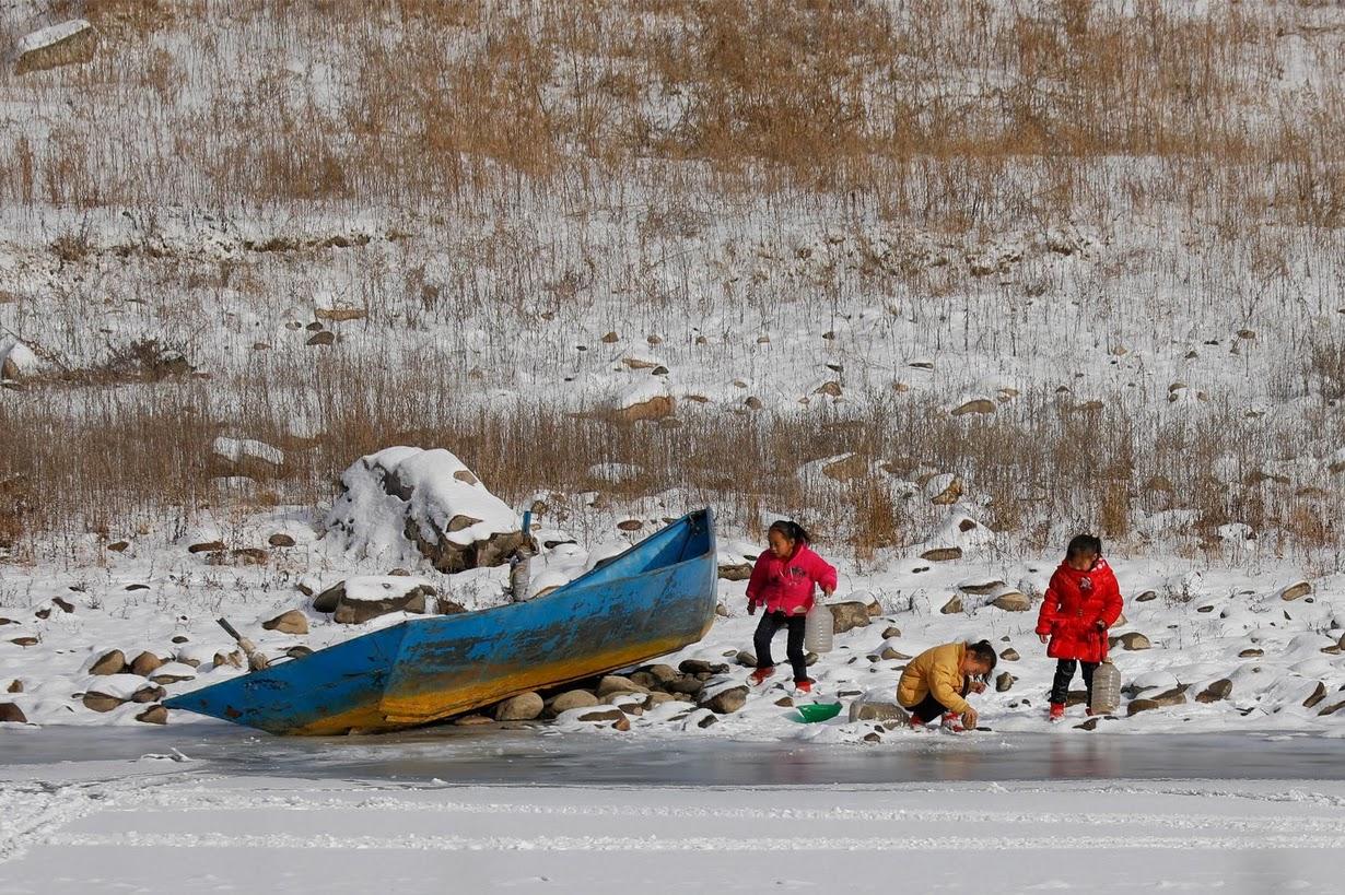 North Korean girls are photographed from the Chinese side of the border as they collect water from the frozen Yalu River near Linjiang, China.