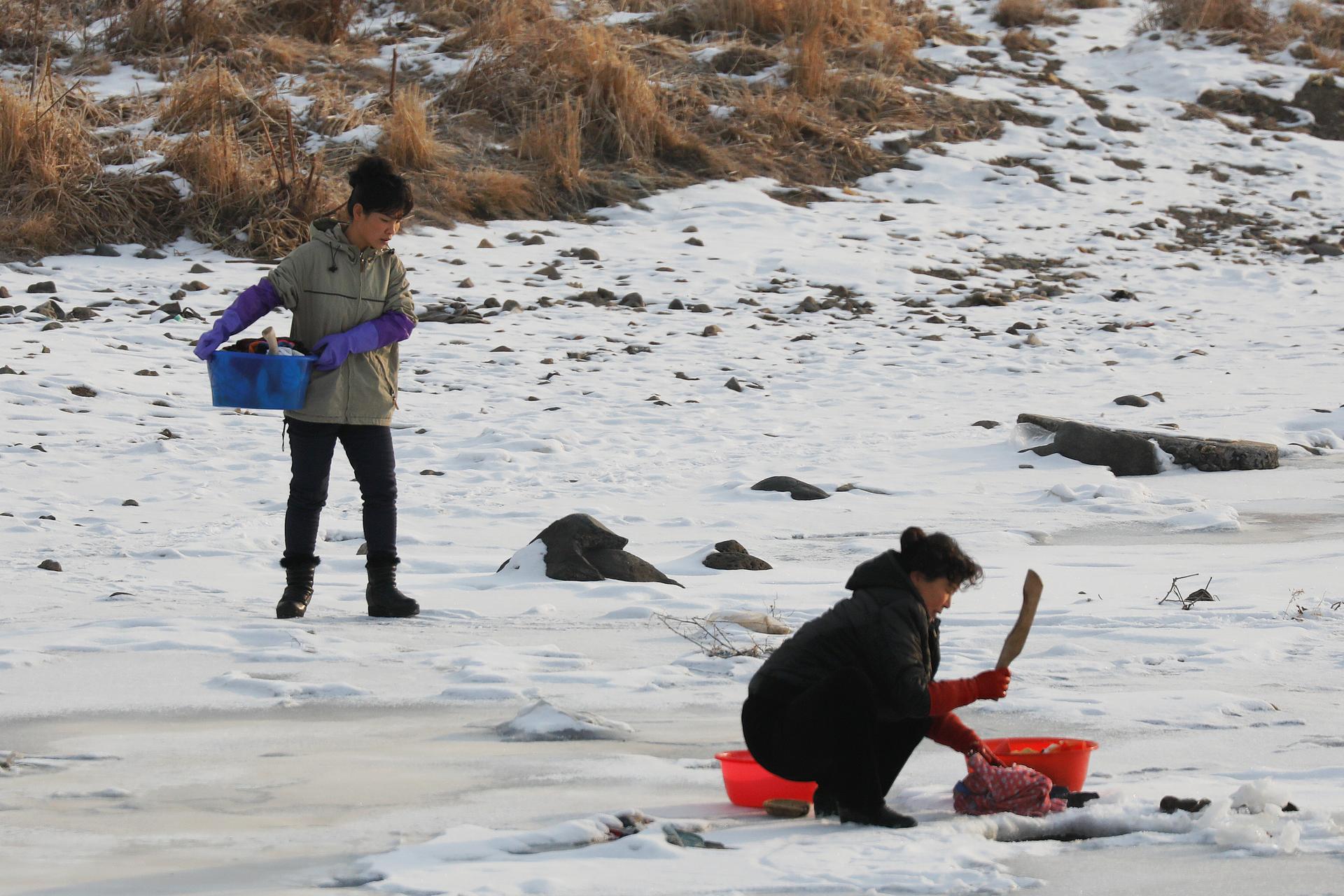 North Korean women as they wash clothes in the frozen Yalu River