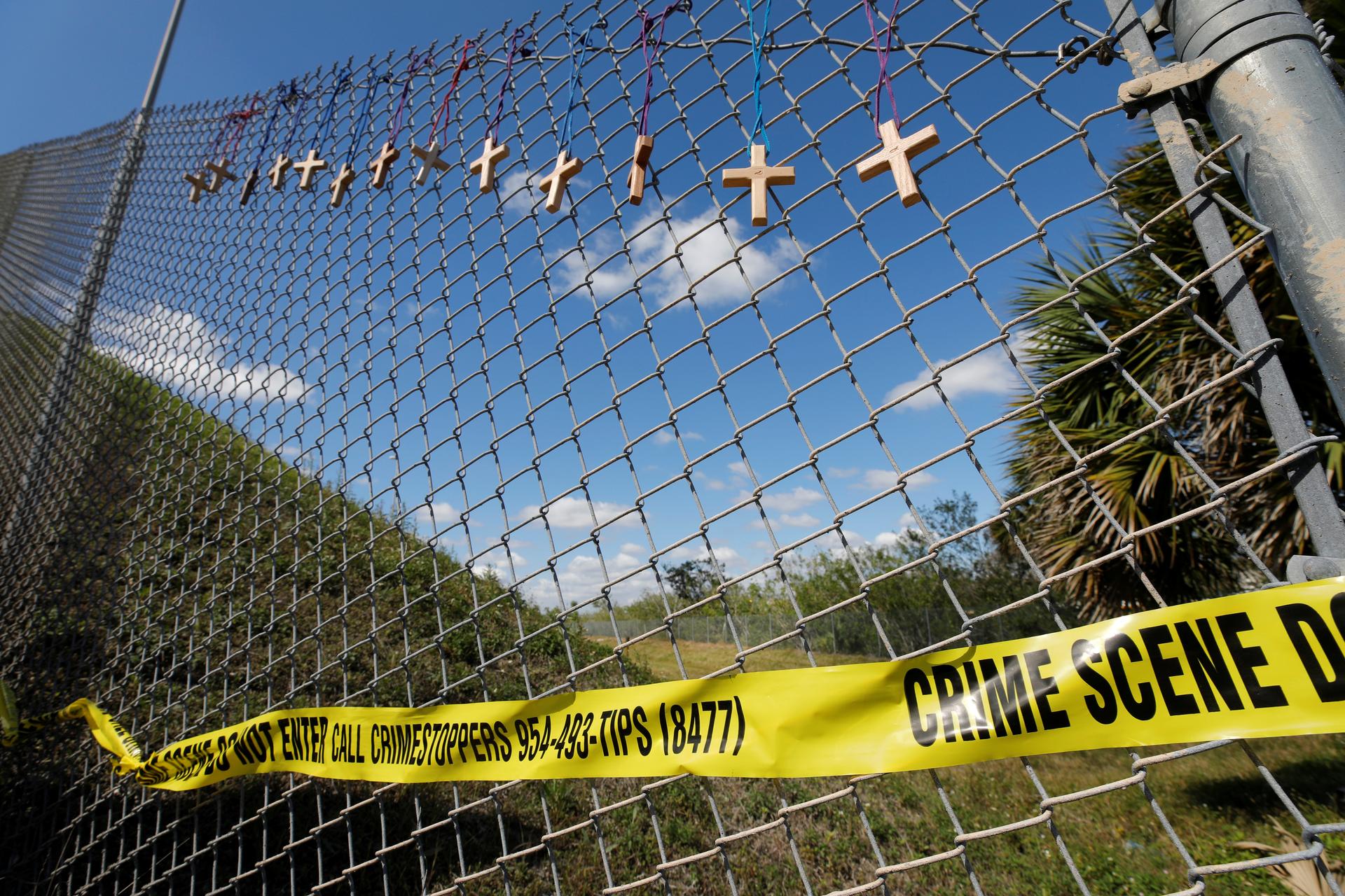 Crosses for the victims of yesterday's shooting at Marjory Stoneman Douglas High School hang on a fence a short distance from the school in Parkland, Florida, February 15, 2018.