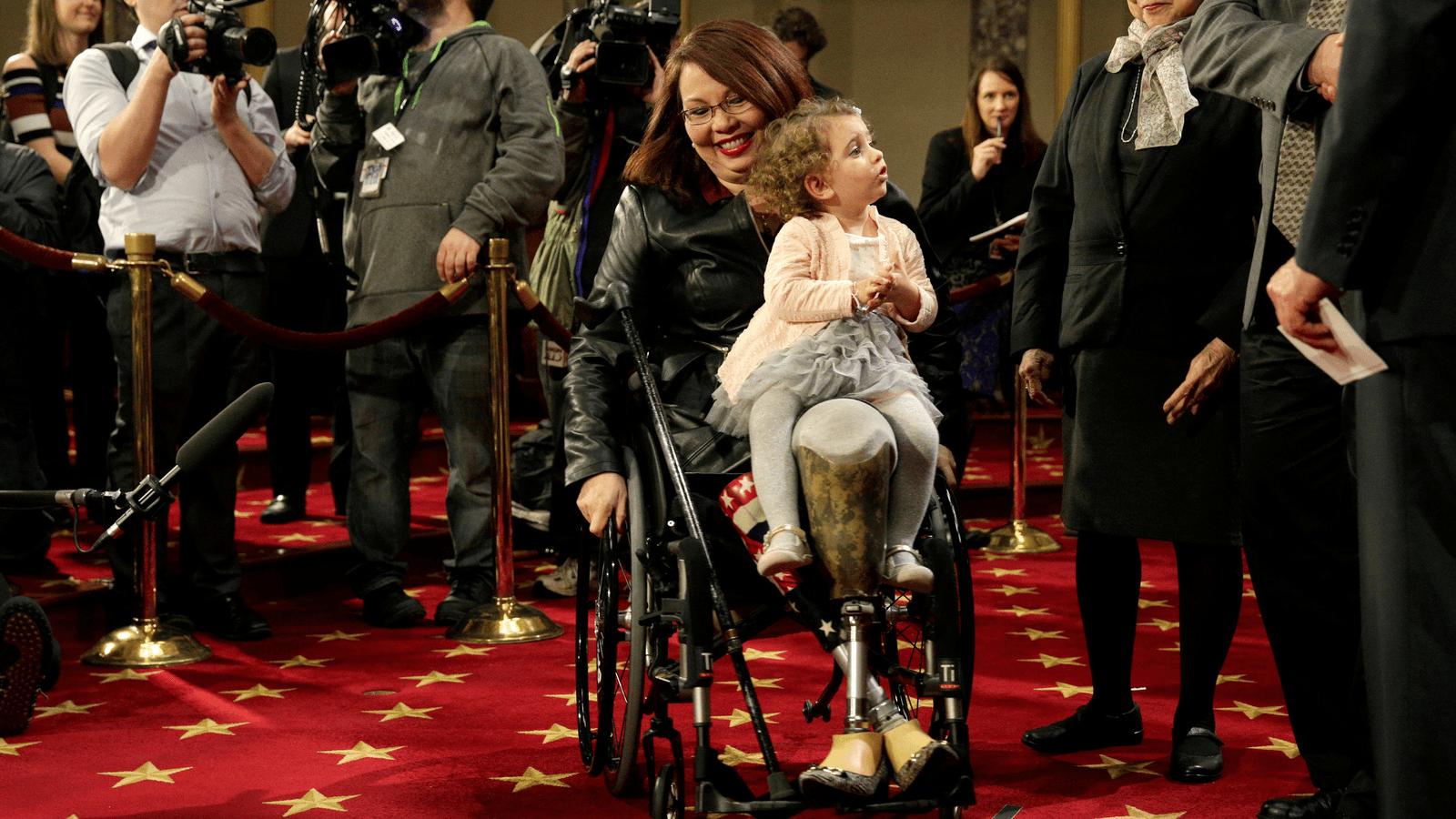 Senator Tammy Duckworth carries her daughter Abigail during a mock swearing-in with US Vice President Joe Biden during the opening day of the 115th Congress on Capitol Hill in Washington, DC, Jan. 3, 2017.