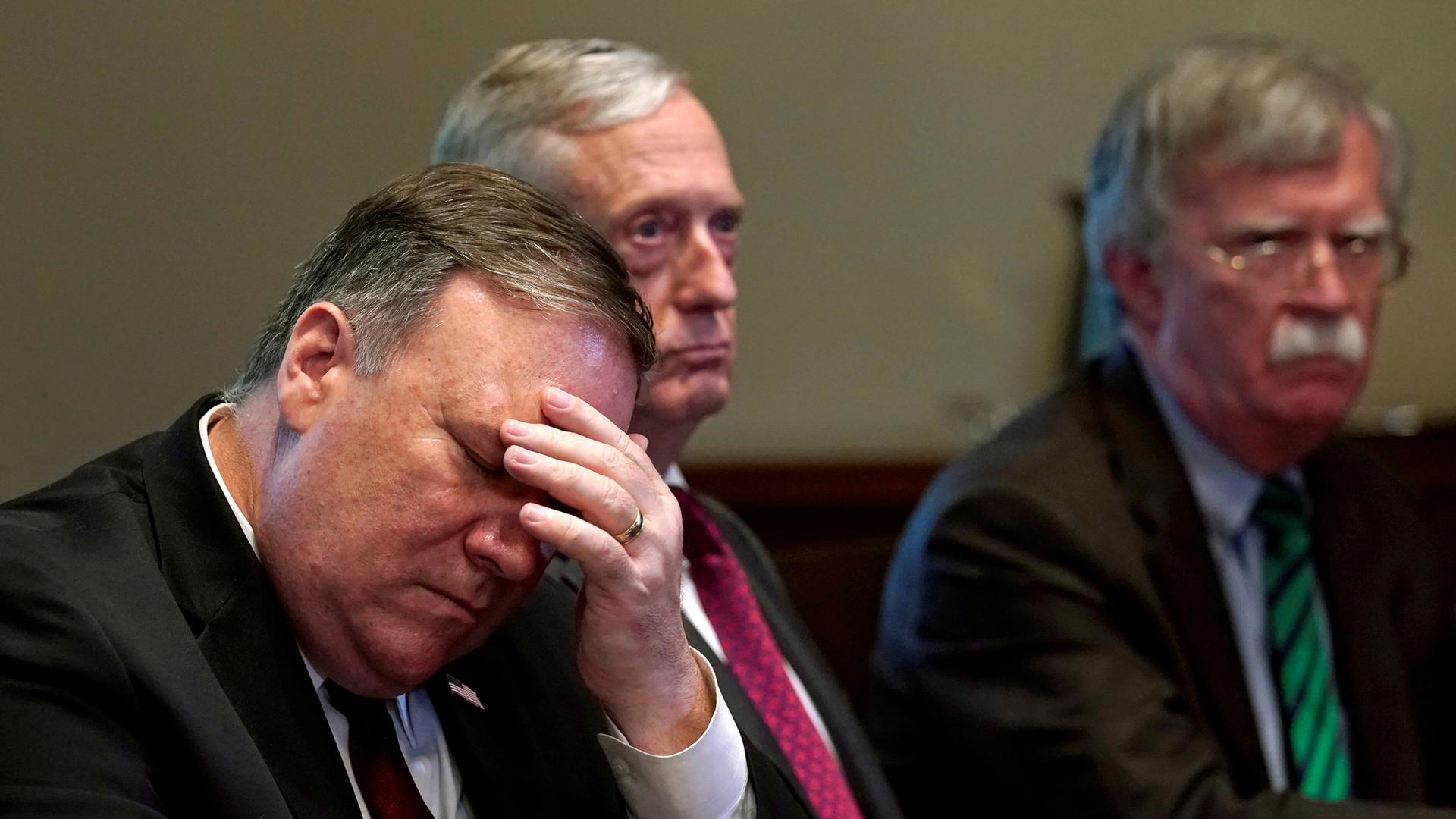 Secretary of State Mike Pompeo is shown with his face in his hand.