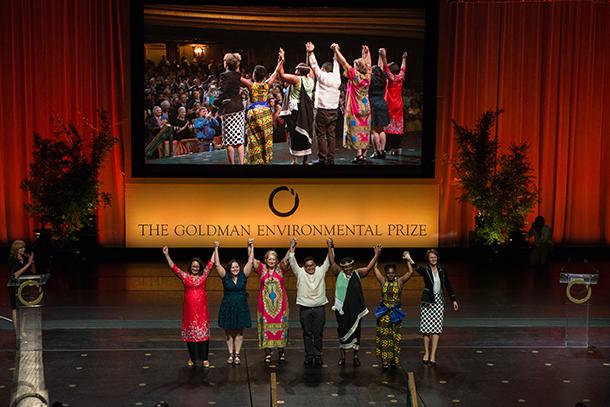 The 2018 Goldman Environmental Prize Recipients hold hands onstage as they accept their awards at a ceremony April 23 in San Francisco.