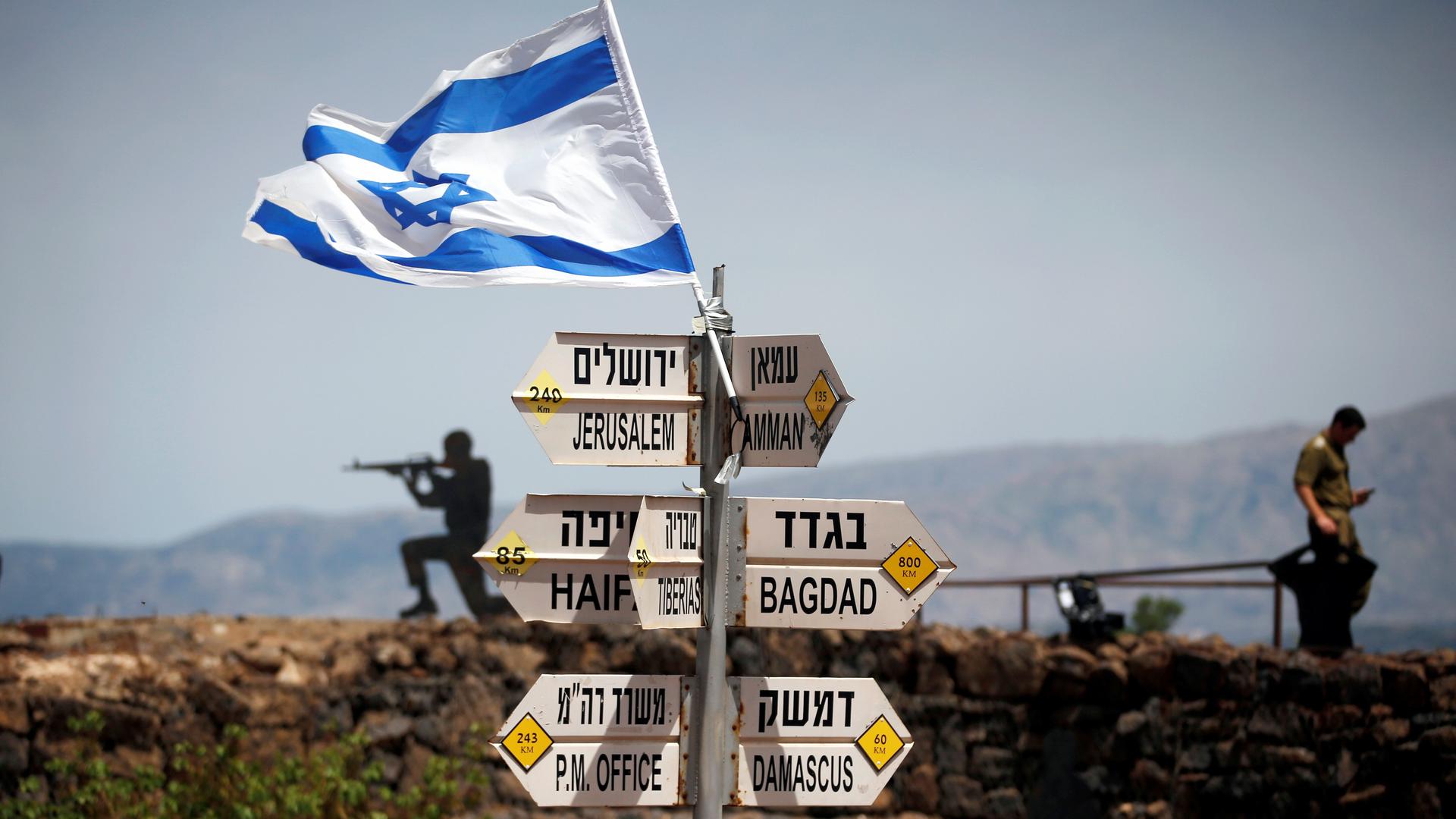 An Israeli soldier stands next to signs pointing out distances to different cities, on Mount Bental, an observation post in the Israeli-occupied Golan Heights that overlooks the Syrian side of the Quneitra crossing, Israel May 10, 2018.