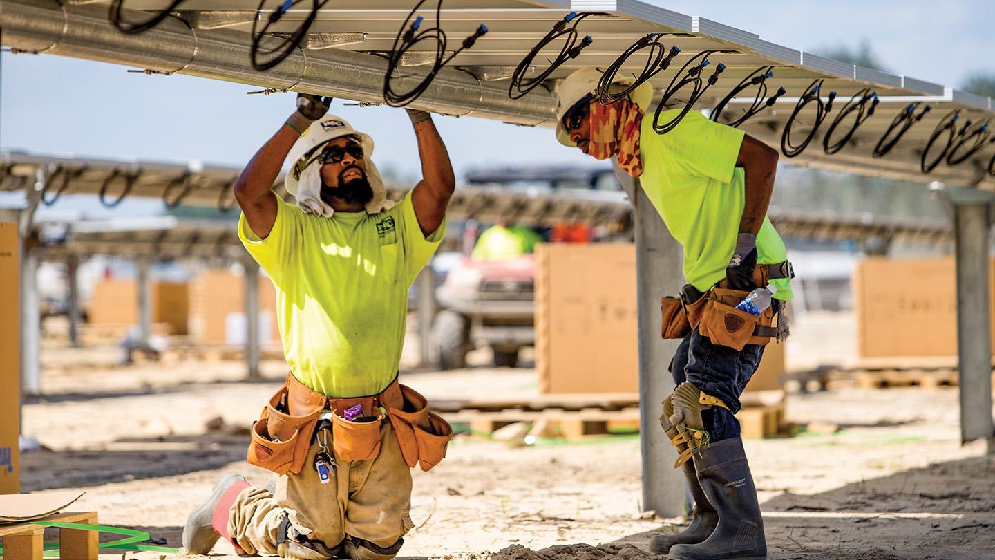 Workers install panels at a solar farm built by Cypress Creek Renewables in Laurinburg, North Carolina. The company has cancelled projects in 10 states since new tariffs were implemented.