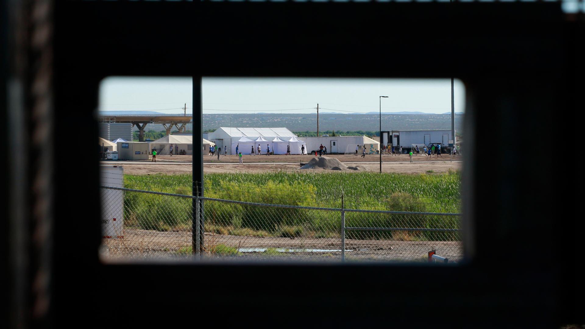 In the distance children of detained migrants are seen play soccer at a tent encampment near the US Customs and Border Protection port of entry in Tornillo, Texas.