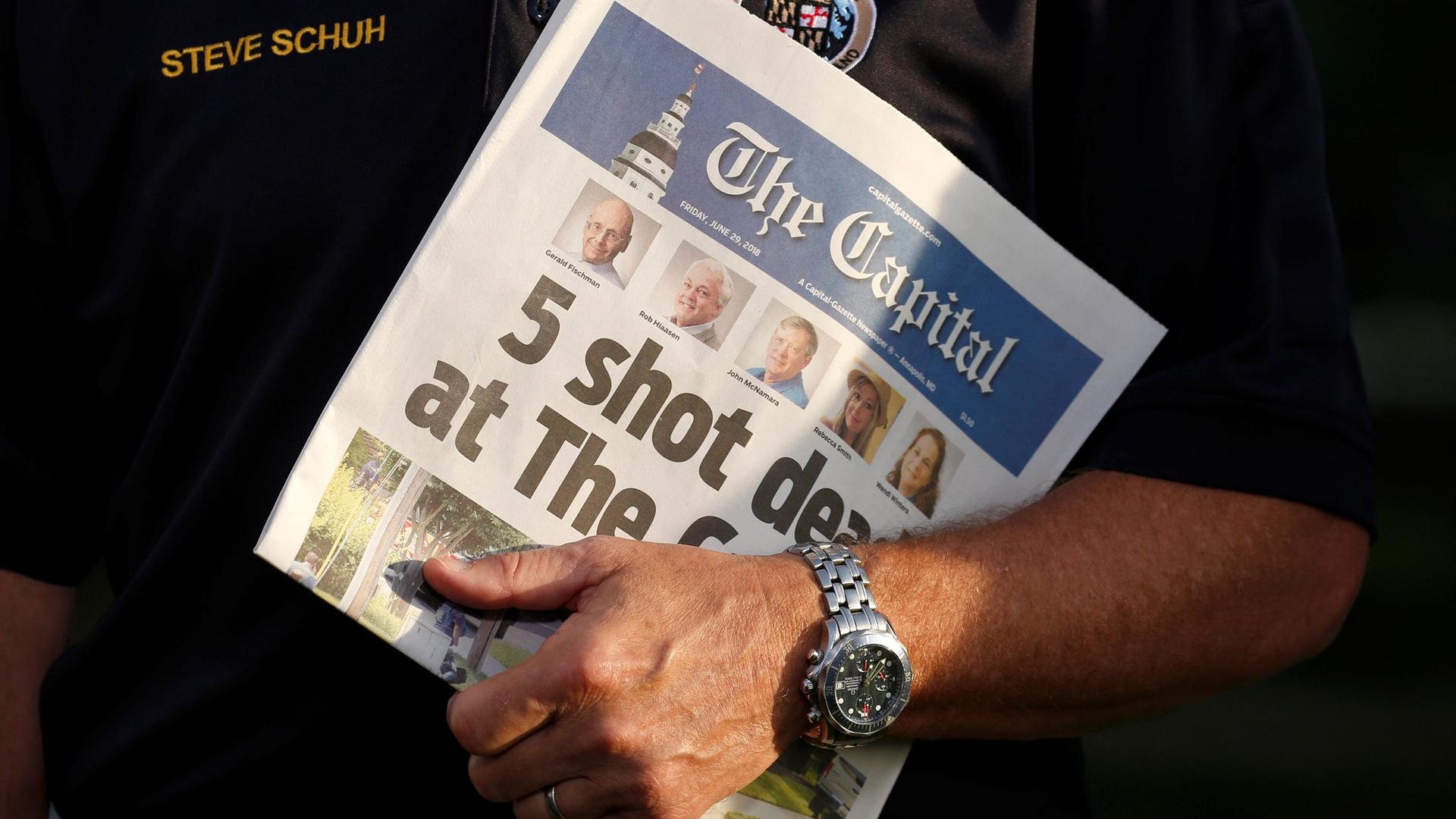 In this close-up photograph, County Executive Steve Schuh holds a copy of the Capital Gazette.