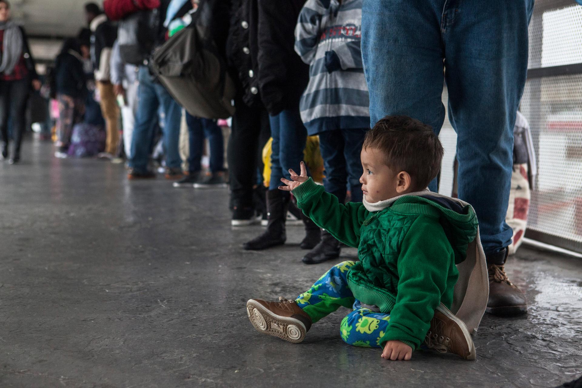 A young Central American boy sits while waiting in the line of asylum seekers who turned themselves in at the U.S. border on Sunday, May 7, 2017.