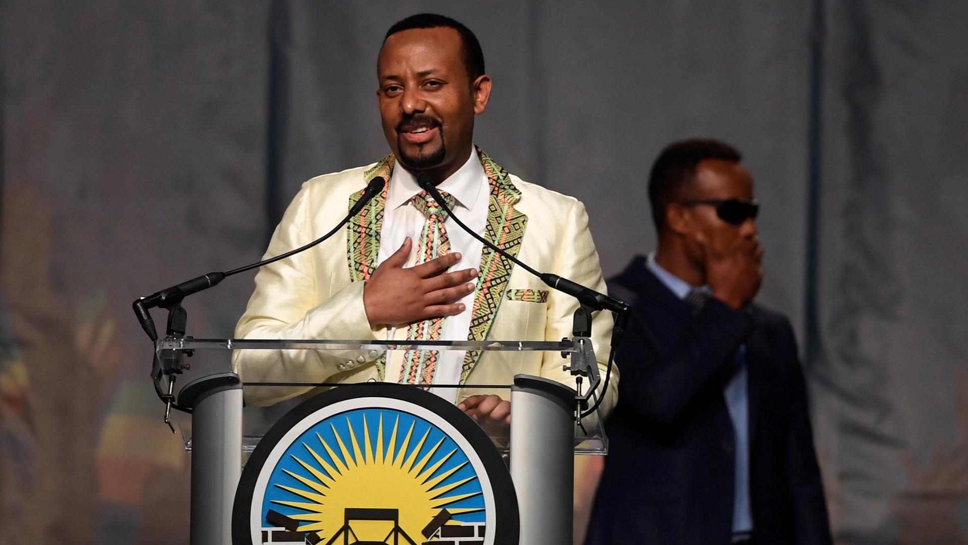 Ethiopian Prime Minister Abiy Ahmed stands at a podium with his hand on his heart as he speaks in Washington DC, July 28, 2018.