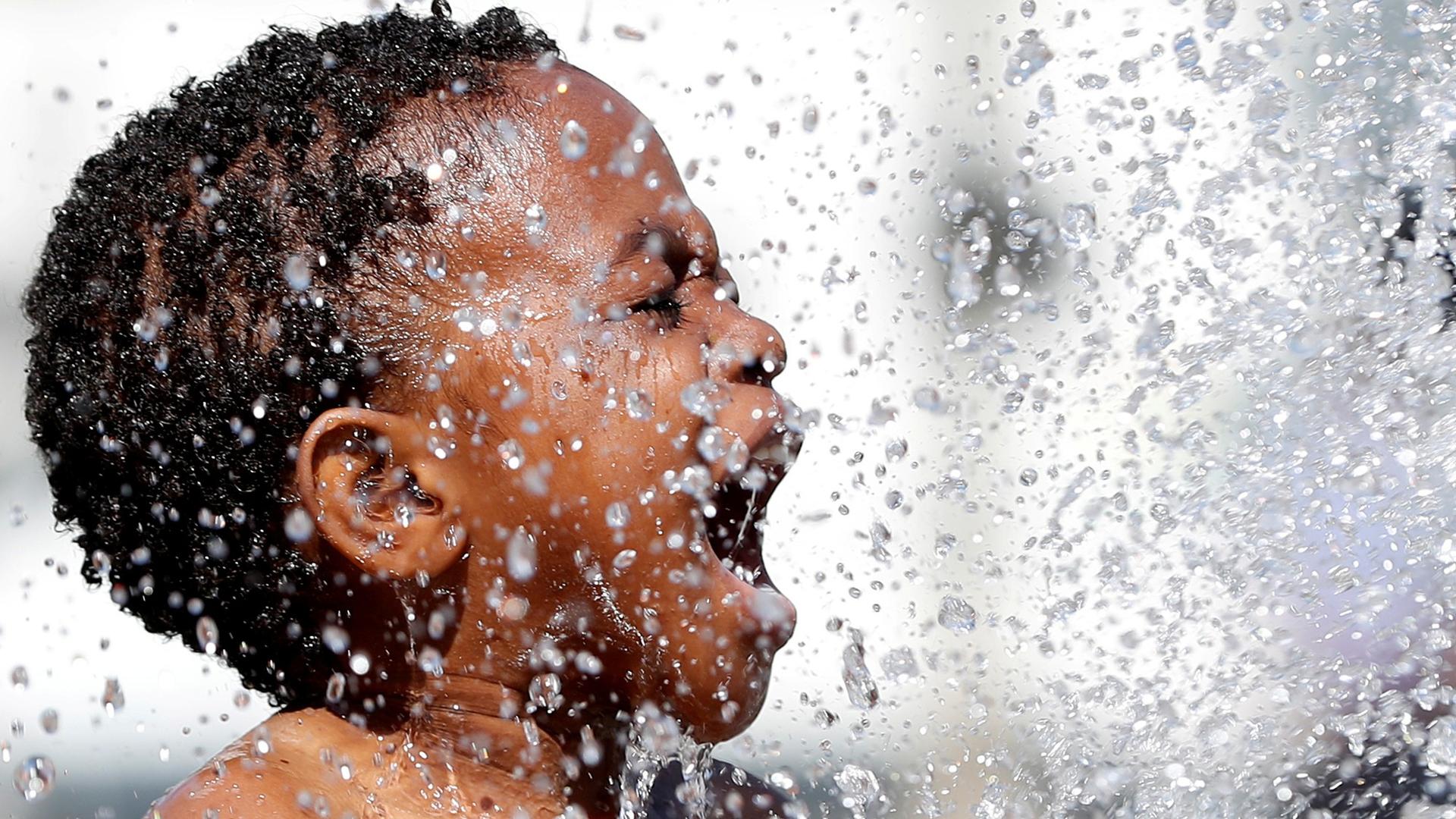 A close-up photo of a boy playing in a fountain in Brussels, Belgium.