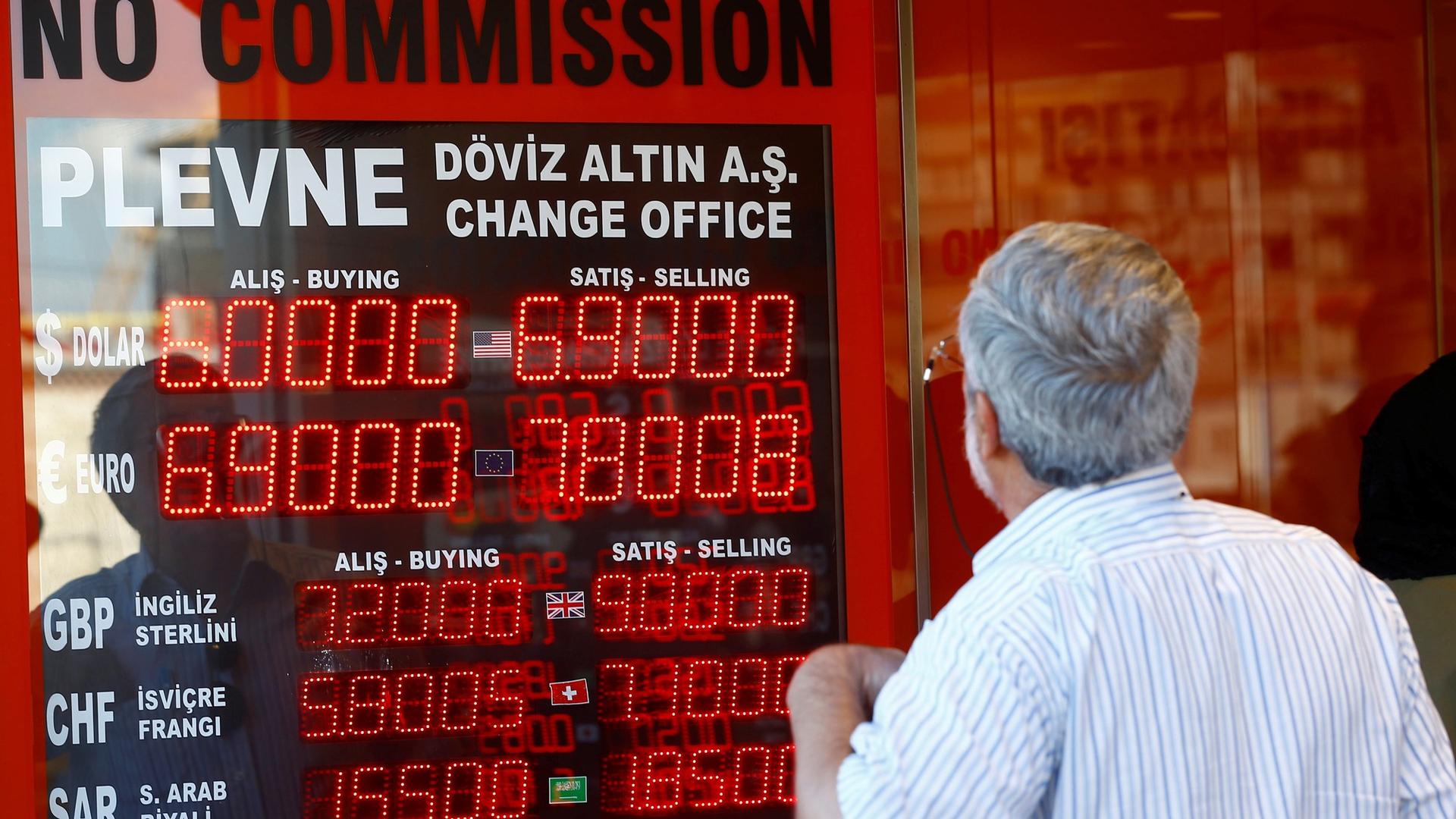 An older man looks to a red display board of a currency exchange office in Istanbul, Turkey, August 13, 2018.
