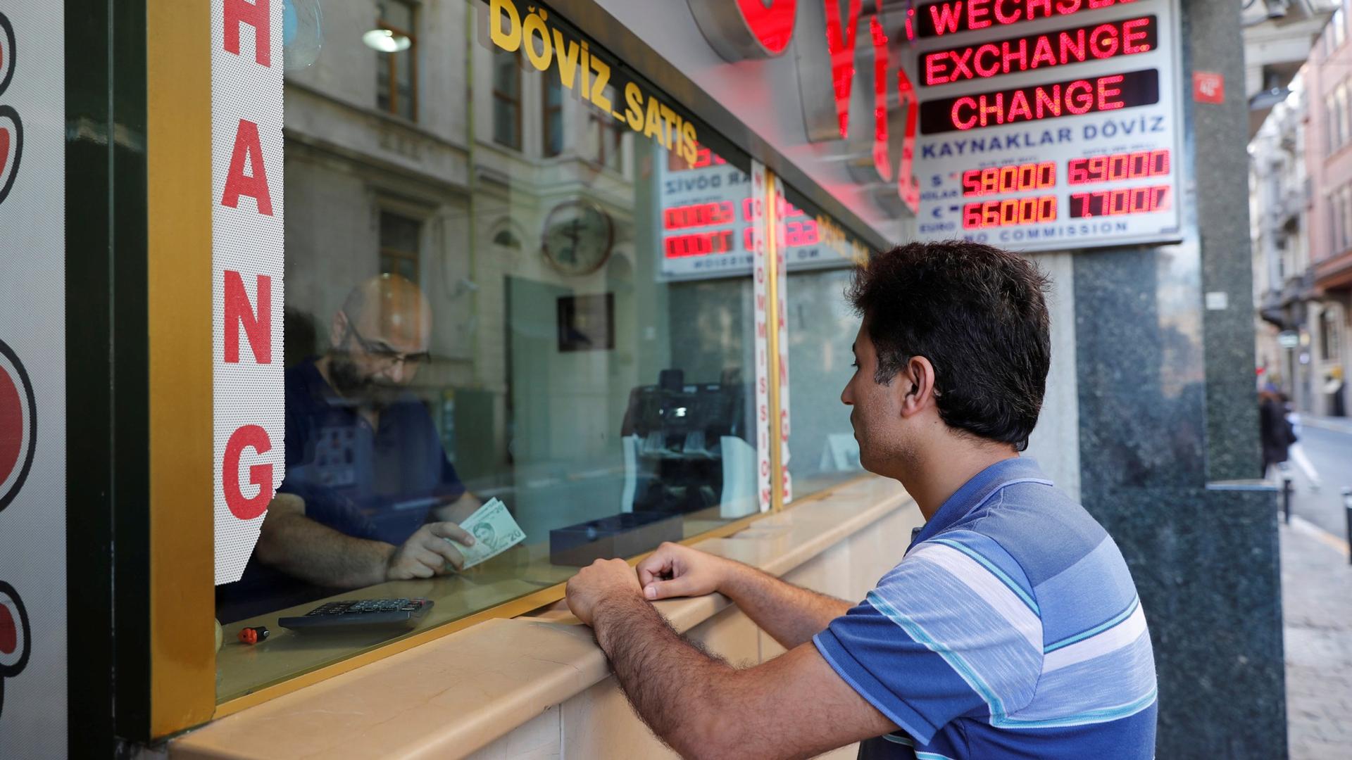 A man leans on the counter to change money at a currency exchange office in Istanbul, Turkey August 13, 2018.