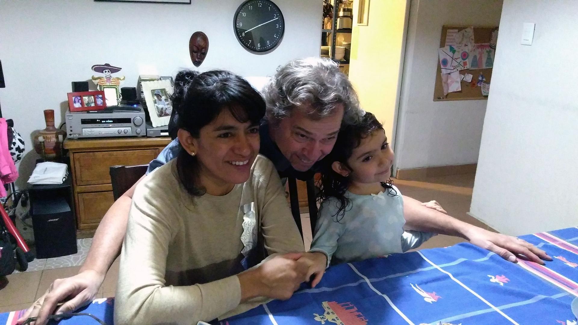 A woman, a man and a child pose a table for a photo