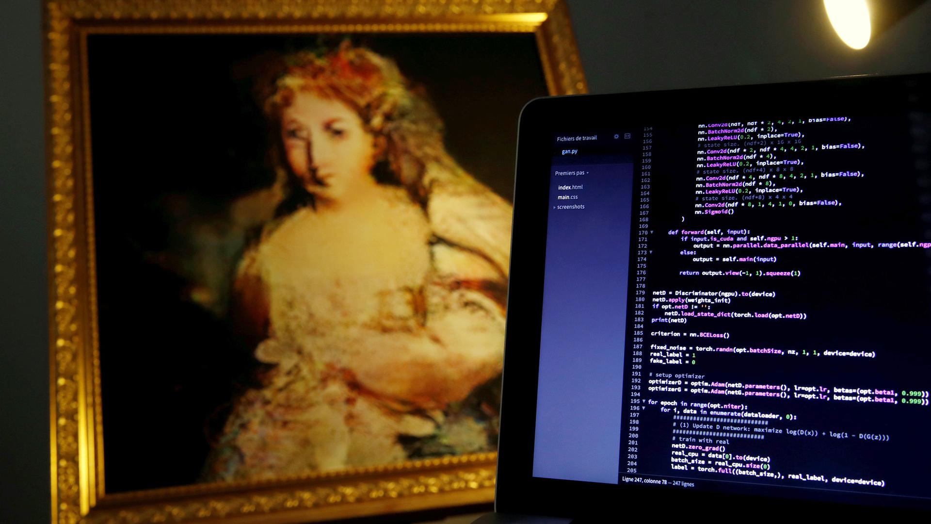 A computer screen of code is next to a copy of a painting