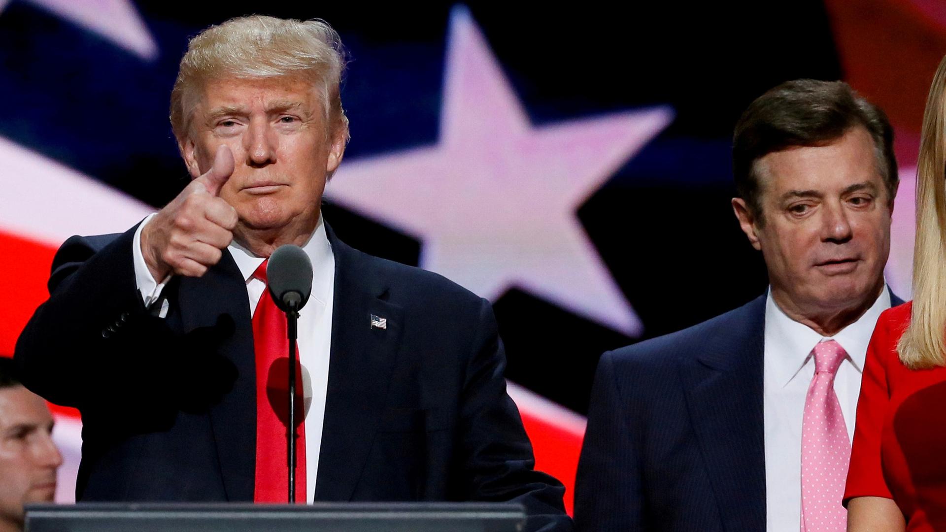 Then Republican presidential nominee Donald Trump gives a thumbs up with former campaign chairman Paul Manafort standing to his left.