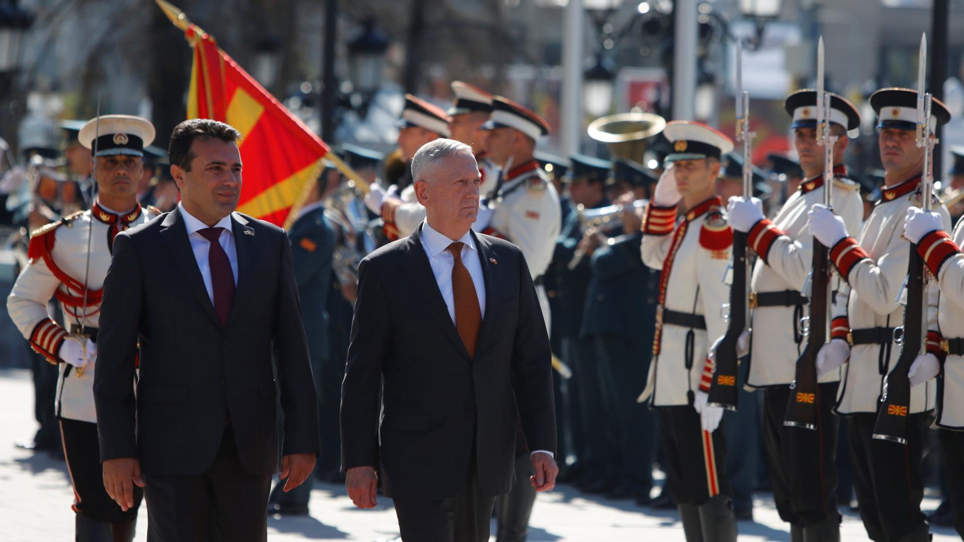 Macedonian Prime Minister Zoran Zaev and US Secretary of Defense James Mattis are shown walking past military officials in dress uniforms during a welcoming ceremony in Skopje.