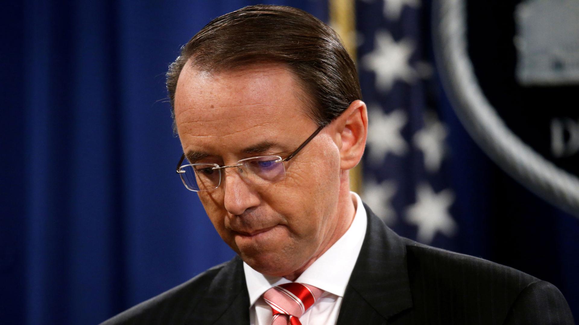 Deputy US Attorney General Rod Rosenstein is shown looking down and red stripped tie.