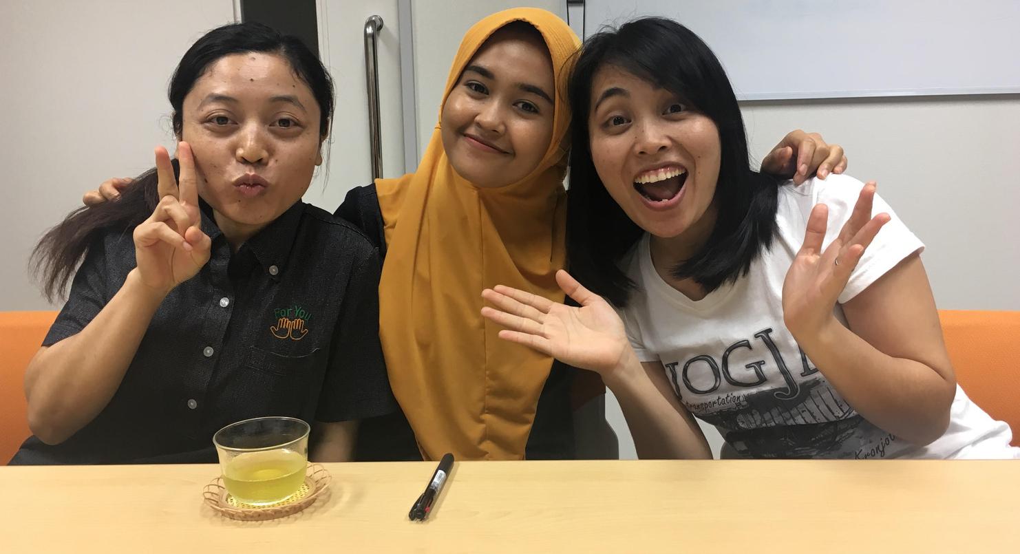 Three young women from Indonesia smile for the camera