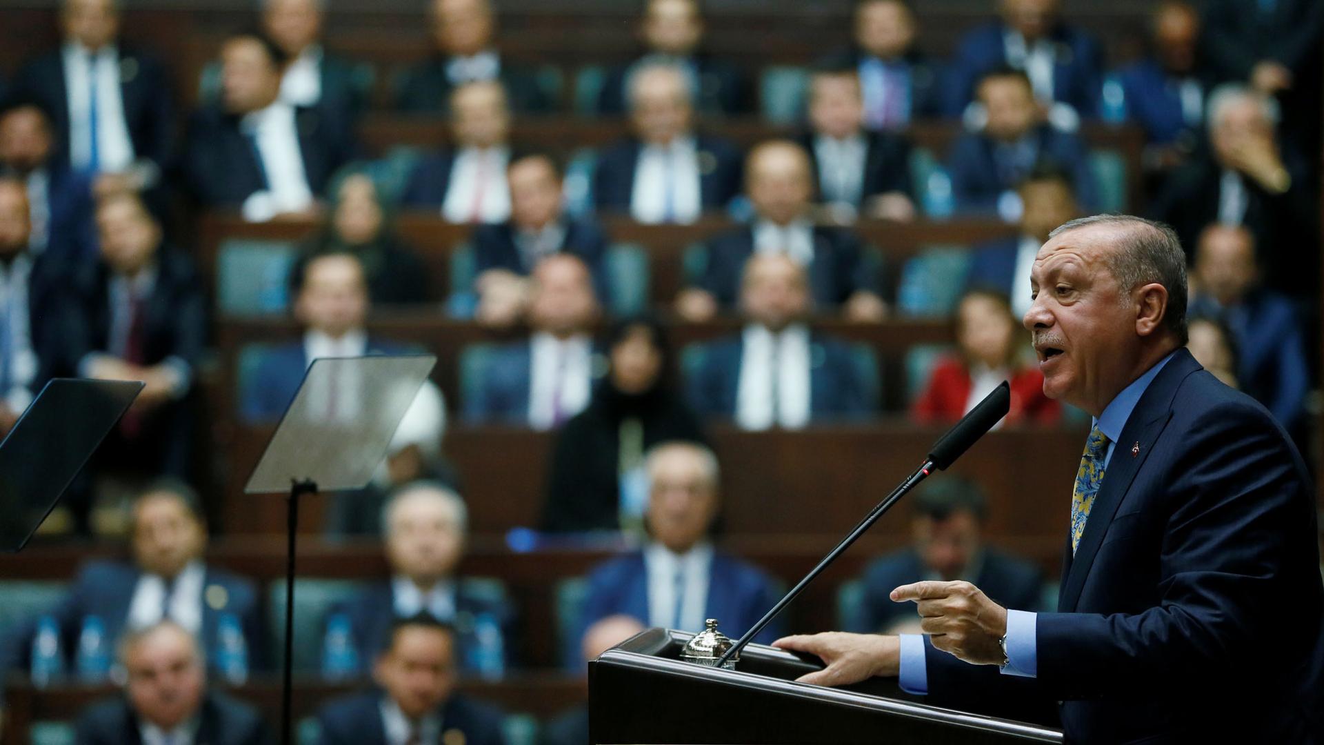 Turkish President Tayyip Erdoğan is shown at a podium addresses members of parliament in Ankara, Turkey.