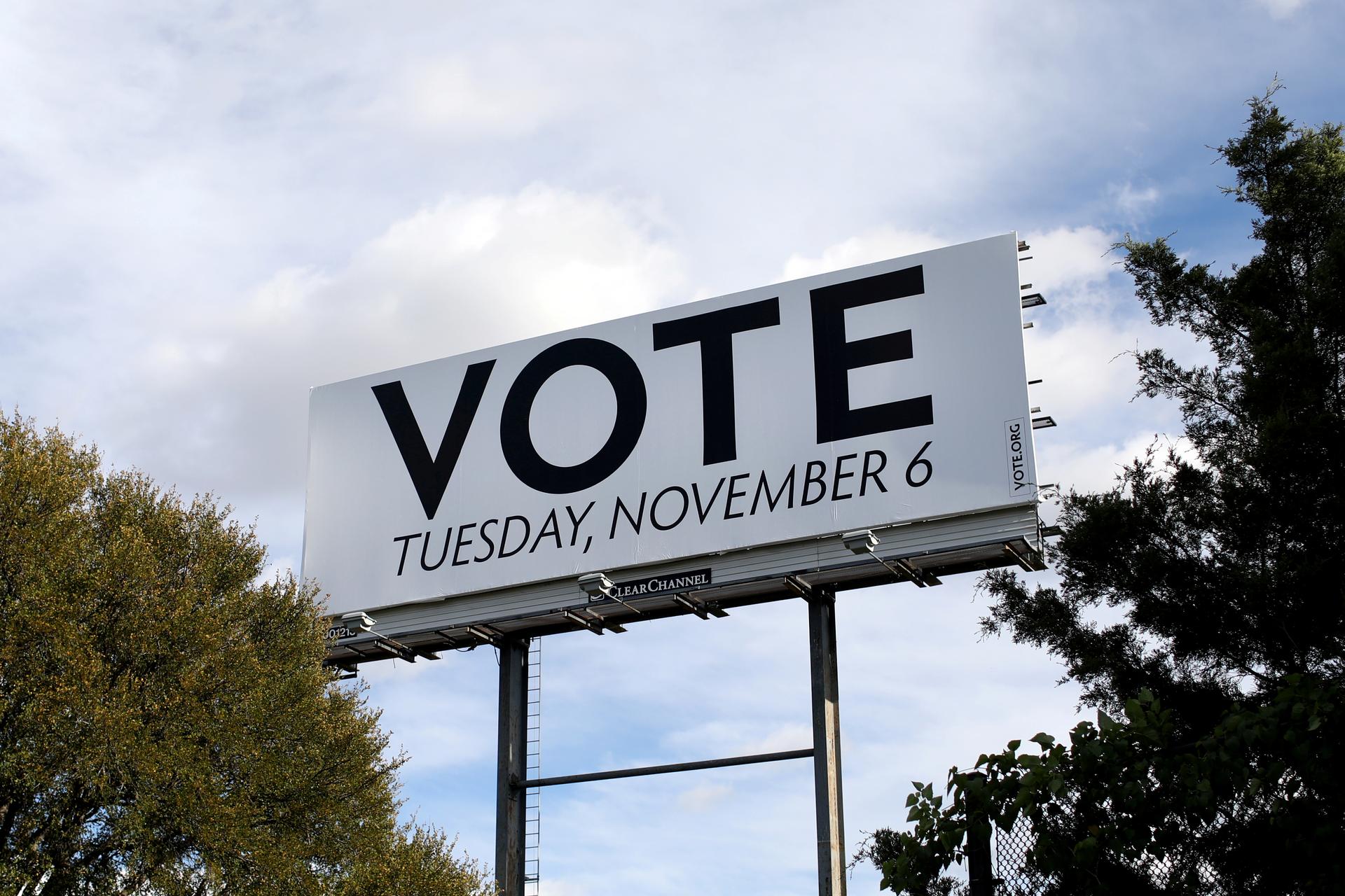 a white billboard with the words "VOTE" on it