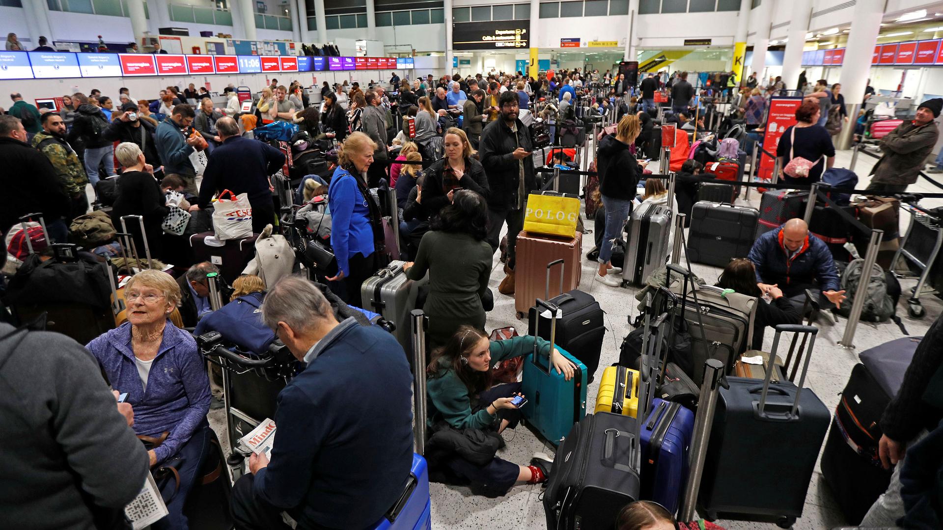 Crowds of people fill an airport terminal.