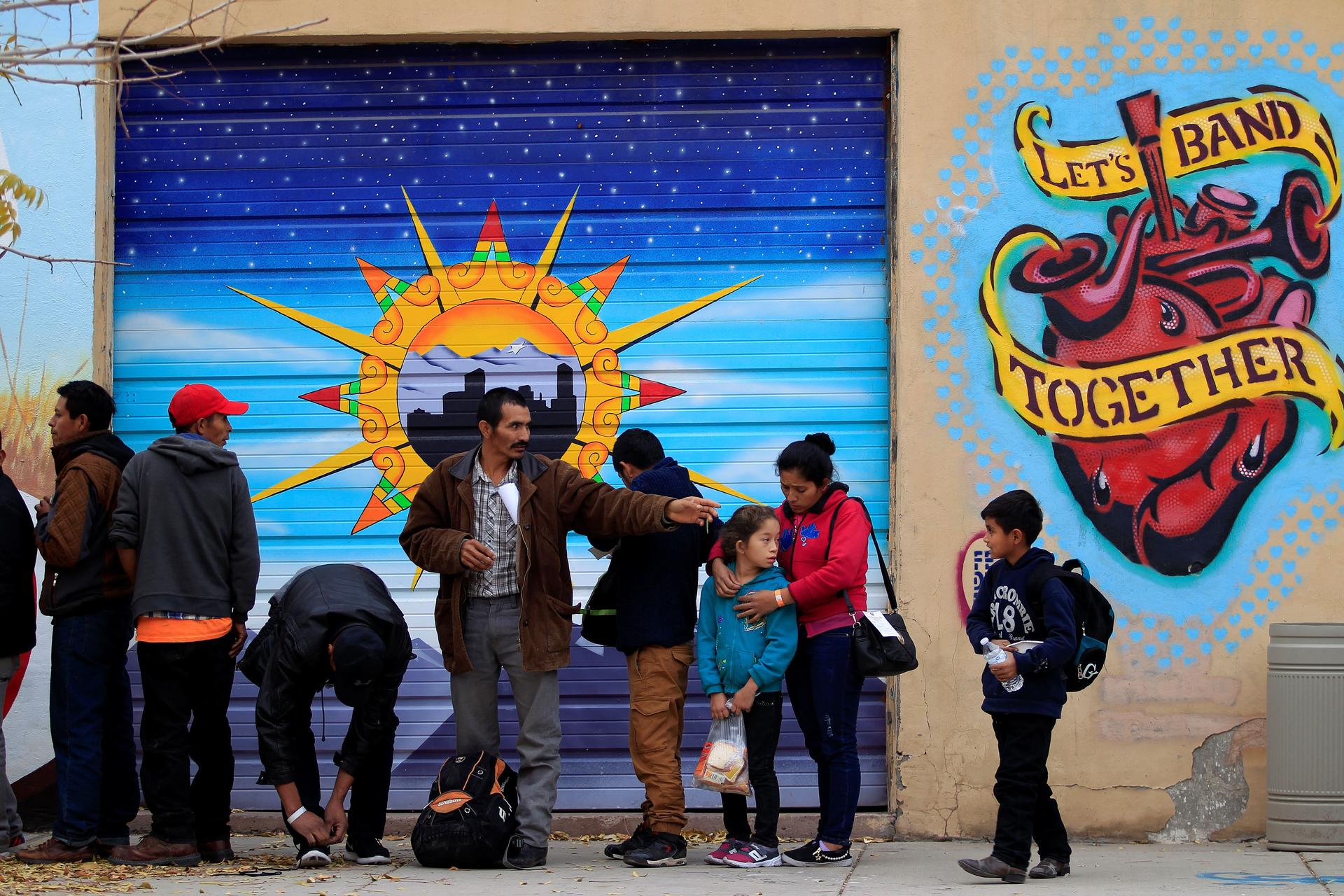 Central American migrants queue for food as they wait for transportation to emergency shelters in El Paso